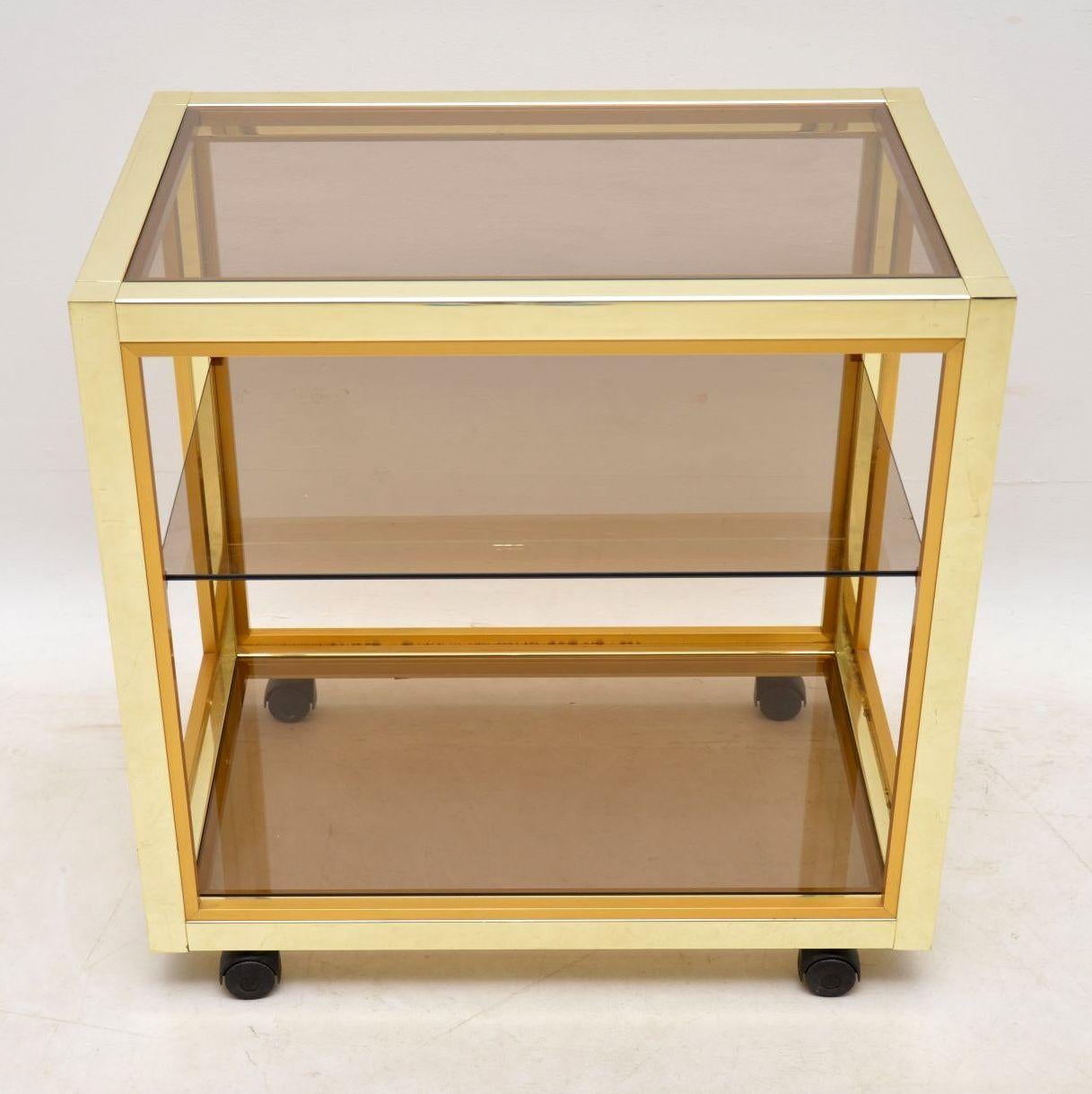 A stunning vintage Italian drinks trolley designed by Renato Zevi, this dates from the 1970’s. The brass plated aluminium frame has some minor surface wear here and there, and some marks around the top edge, but overall the condition is very good