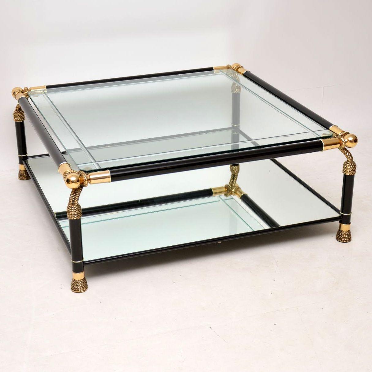 A large and absolutely stunning, extremely well made vintage coffee table, this was made in Italy in the 1970s. It has a black aluminum frame with brass supports, a mirrored base and a thick, engraved, beveled edge glass top. This is in great