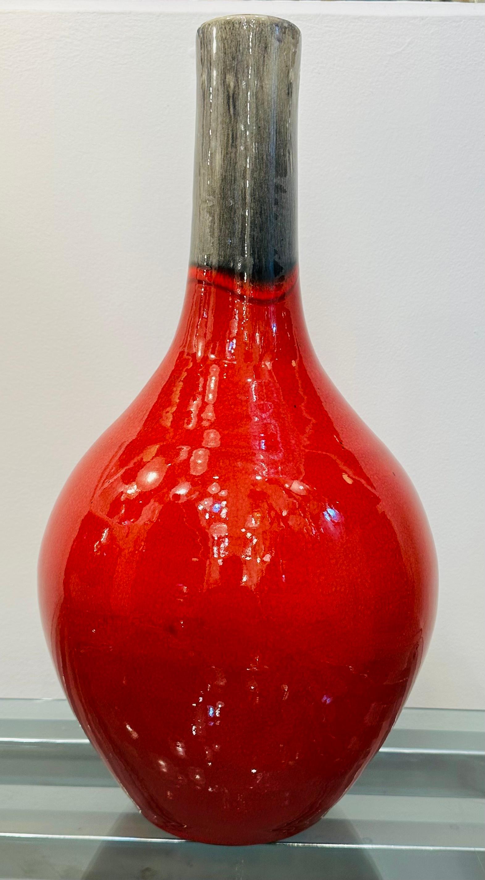  Eine große rot und grau gesprenkelte Keramikvase aus den 1970er Jahren mit Glasur.  Der bauchige Körper in intensivem, gesprenkeltem Rot mit einer wunderbar schimmernden Glasur verjüngt sich zum Hals hin, wo die Farbe in ein schmelzendes Grau mit