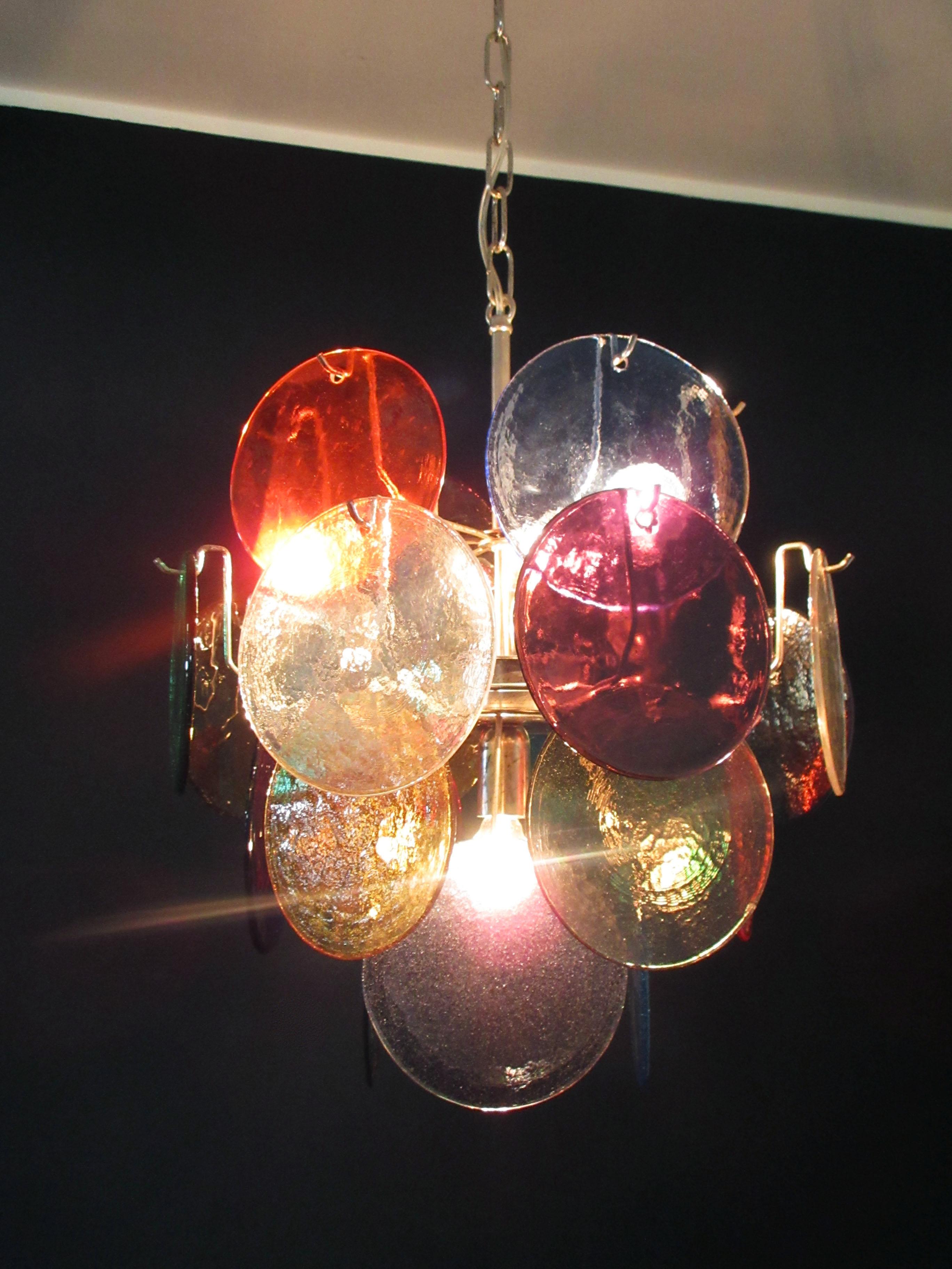 Vintage Italian Murano chandelier in Vistosi style. The chandelier has 24 fantastic Murano multicolored disks in a metal frame.
Period: late 20th century
Dimensions: 41,30 inches (105 cm) height with chain; 20,50 inches (52 cm) height without
