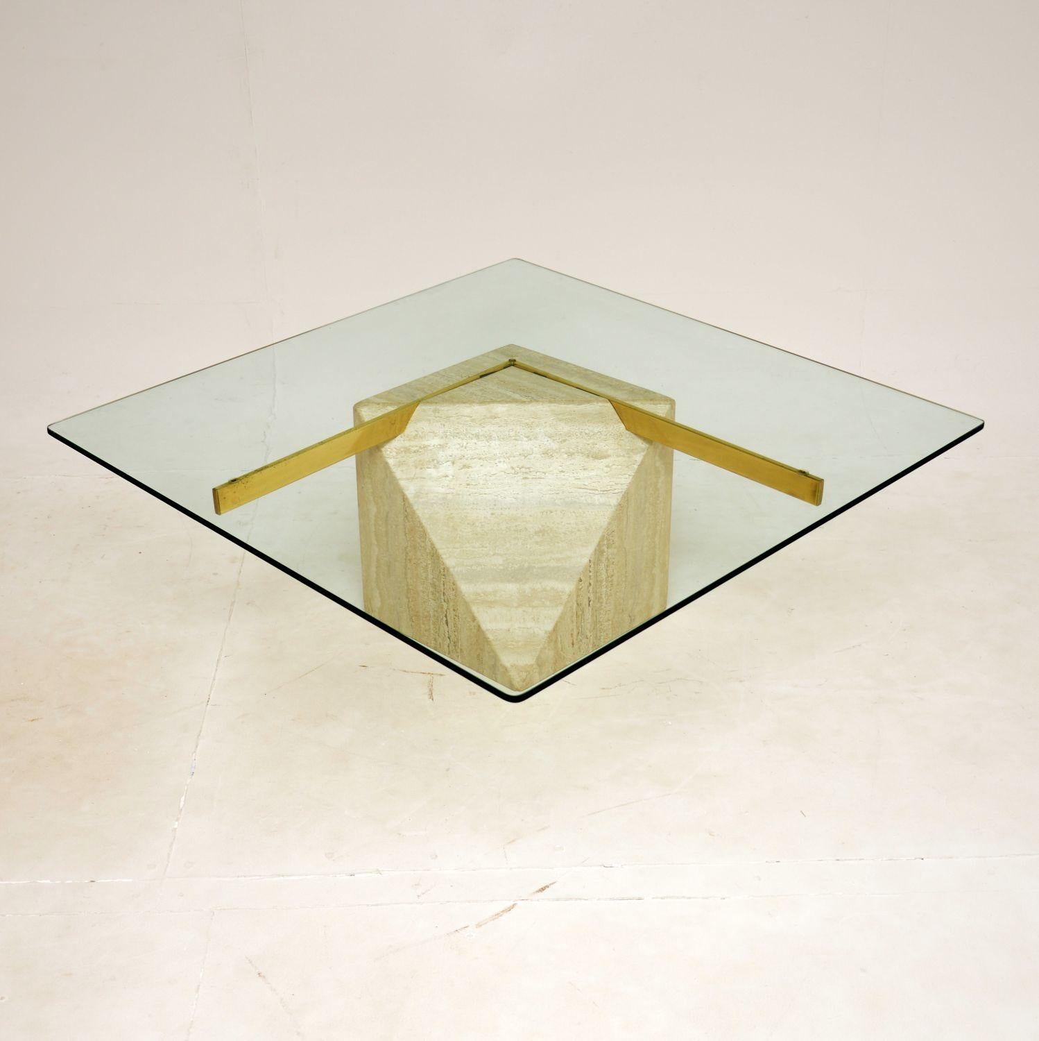 A wonderful vintage Italian coffee table by Artedi, dating from the 1970’s.

It has a beautifully sculpted travertine base, with a V shaped brass support and thick, toughened glass top.

This is in superb condition, with no damage and only some