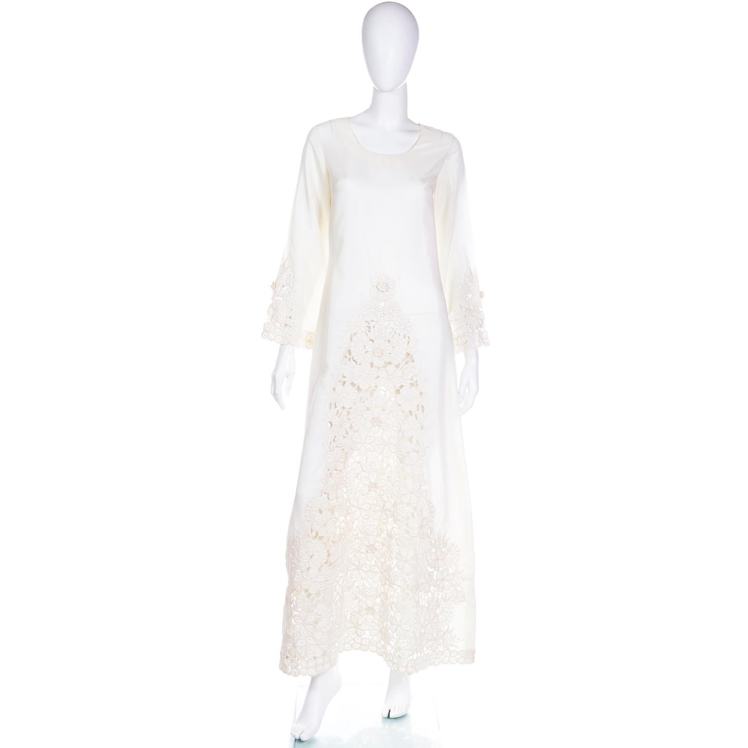 This beautiful vintage ivory cutwork maxi dress was purchased at the shop in The Shangri La Hotel in Singapore in the 1970's. The fabric feels like a nylon blend and we are obsessed with the fabulous guipure lace found on the front and at the