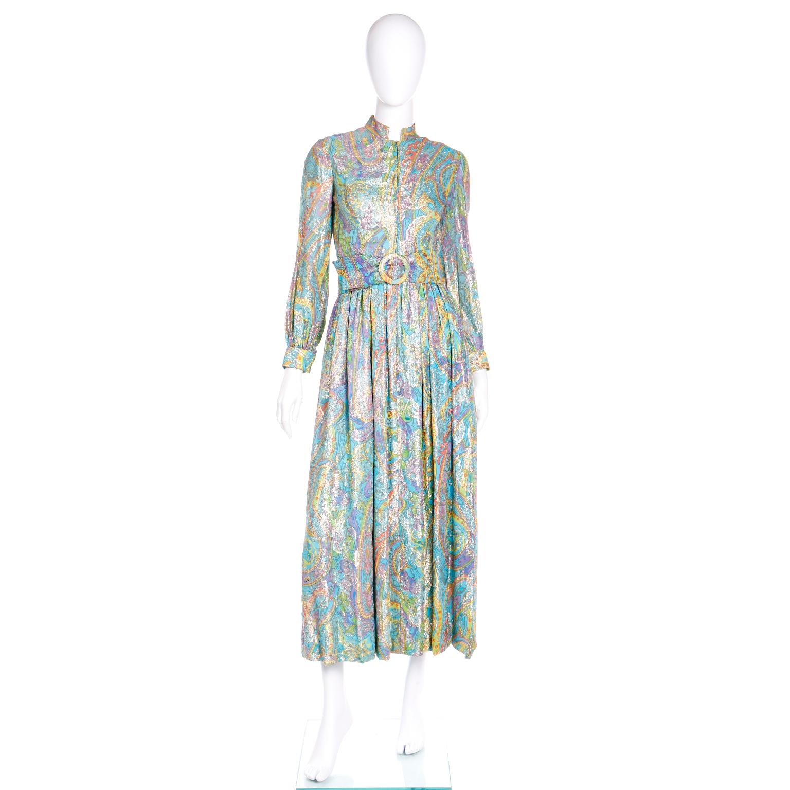 This fun vintage Larry Aldrich maxi dress is from the late 1960's or early 1970's and it is in a gorgeous paisley print in shades of blue, yellow, green, orange, and purple with gold metallic woven in the print. We love dresses like these because