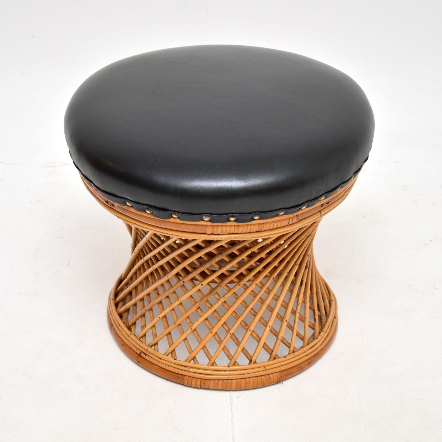 Un tabouret vintage élégant et inhabituel en bambou et osier avec une assise en cuir noir. Il a été fabriqué en Angleterre, il date des années 1970 environ.

Il est d'une belle taille et d'une belle facture. Le cadre en rotin tressé a une forme de