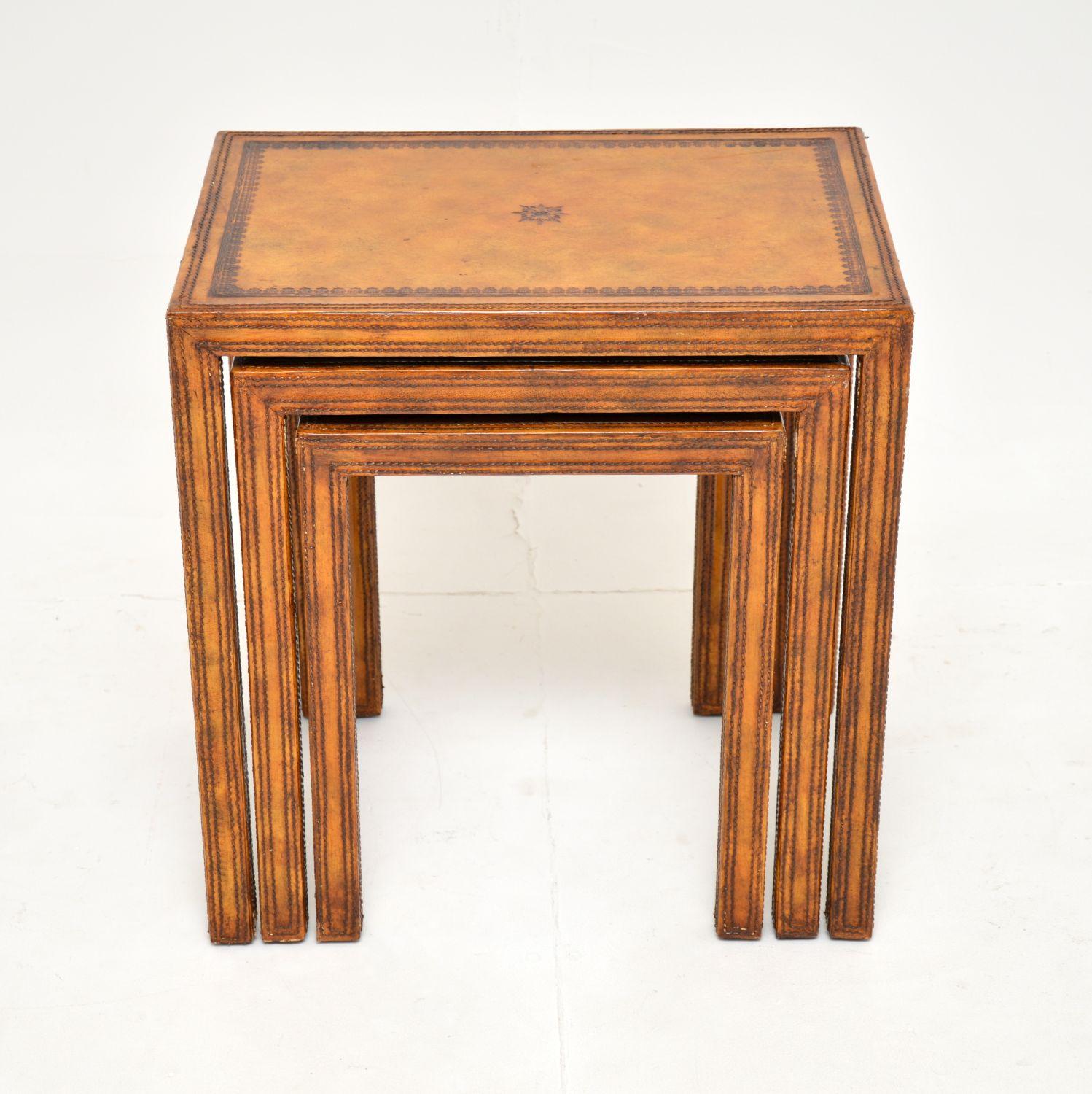 A fantastic vintage leather bound nest of tables, these were made in England and date from around the 1950’s.

They have a beautiful and unusual design, and are very well made. They are entirely clad in hand coloured, gold tooled leather. They have