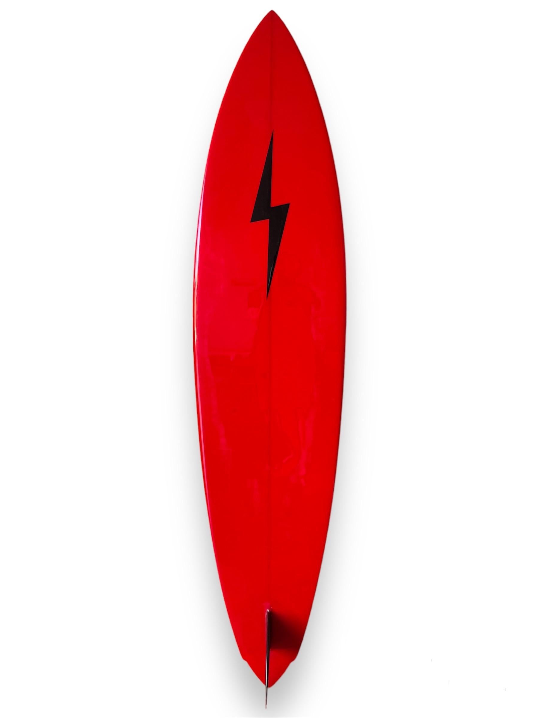 Early-1970s Lightning Bolt surfboard made by Barry Kanaiaupuni. Features large and wide lightning bolt jag design, a telltale sign of the earliest of Lightning Bolt surfboards. Beautiful red lightning bolt with red wrapped rails and pinstriping.