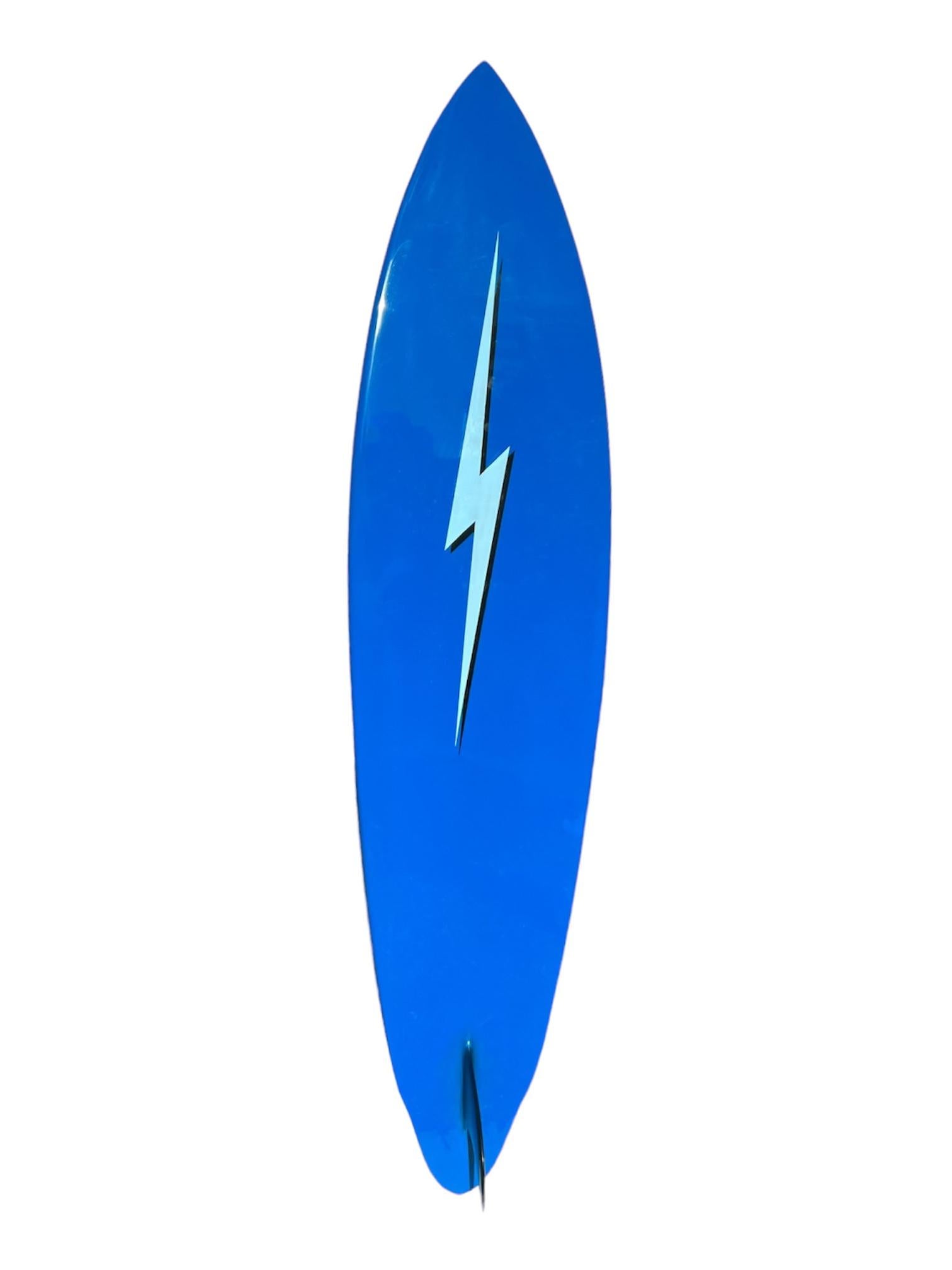 Mid-1970s Vintage Lightning Bolt surfboard made by Barry Kanaiaupuni. Features stunning blue shades with visually enhancing black shadows. Complimented by intricate rail lightning bolts that transform into pinstripes outlining the entire board. A