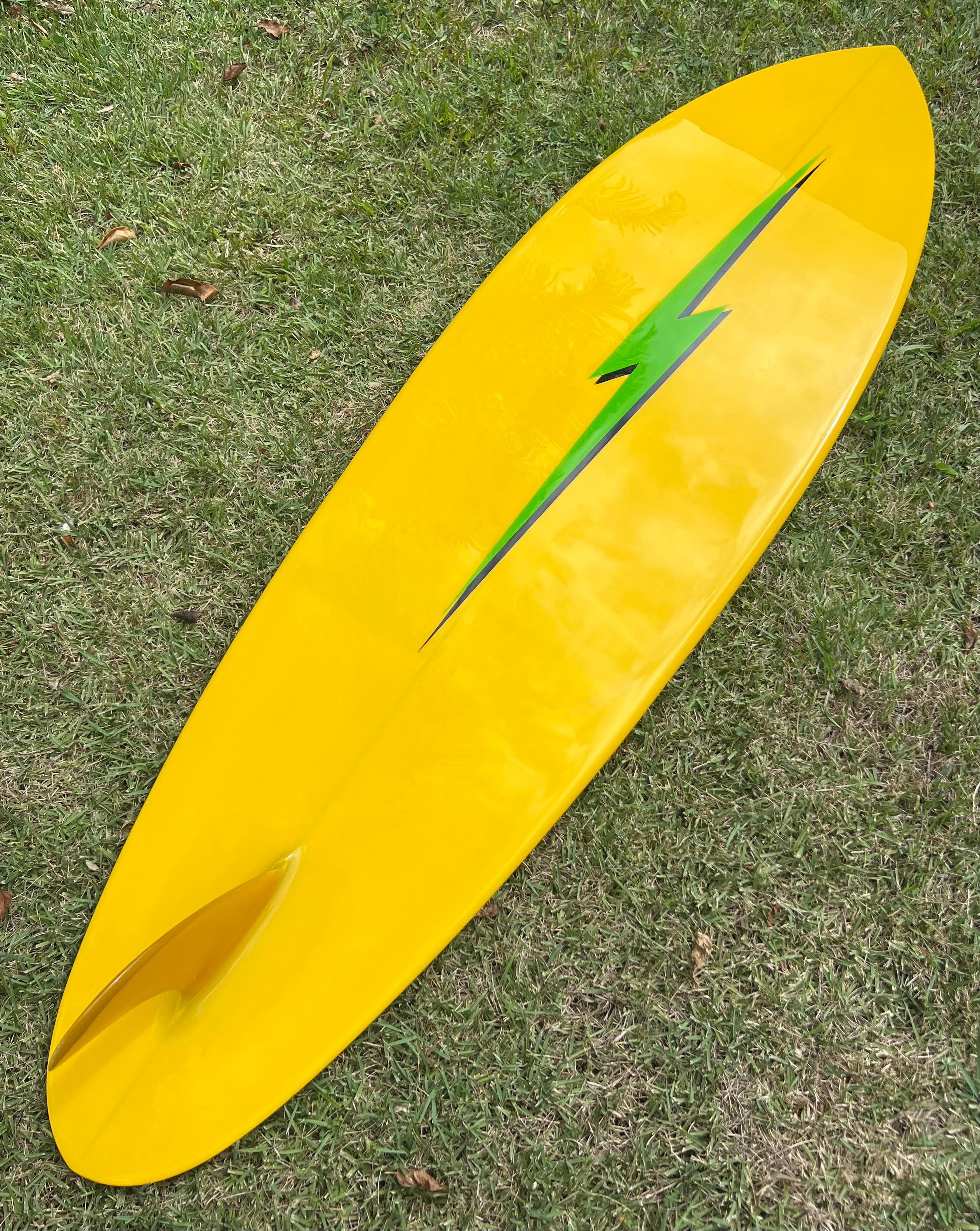 1970s Vintage Lightning Bolt surfboard shaped by Bill Barnfield. Features rounded pintail shape with bright green tinted deck, yellow bottom, and black rail-bolts. A striking example of a fully restored vintage 1970s Lightning Bolt surfboard. 