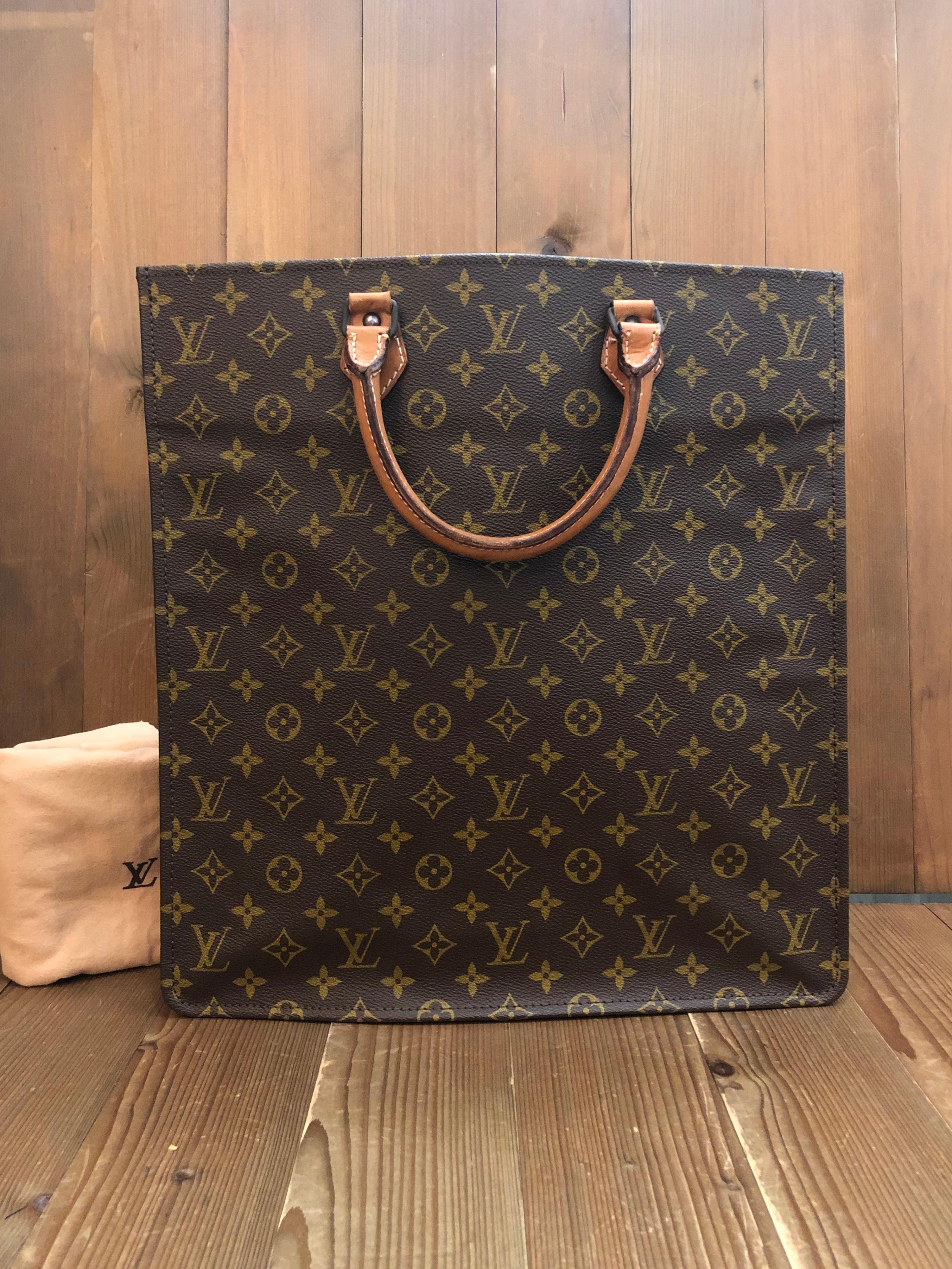 This rare 1970s vintage LOUIS VUITTON Sac Plat is crafted of Louis Vuitton’s monogram canvas in brown and vachetta leather featuring brass hardware and exposed seams along the sides to the bottom. Wide top opens to a spacious interior lined with