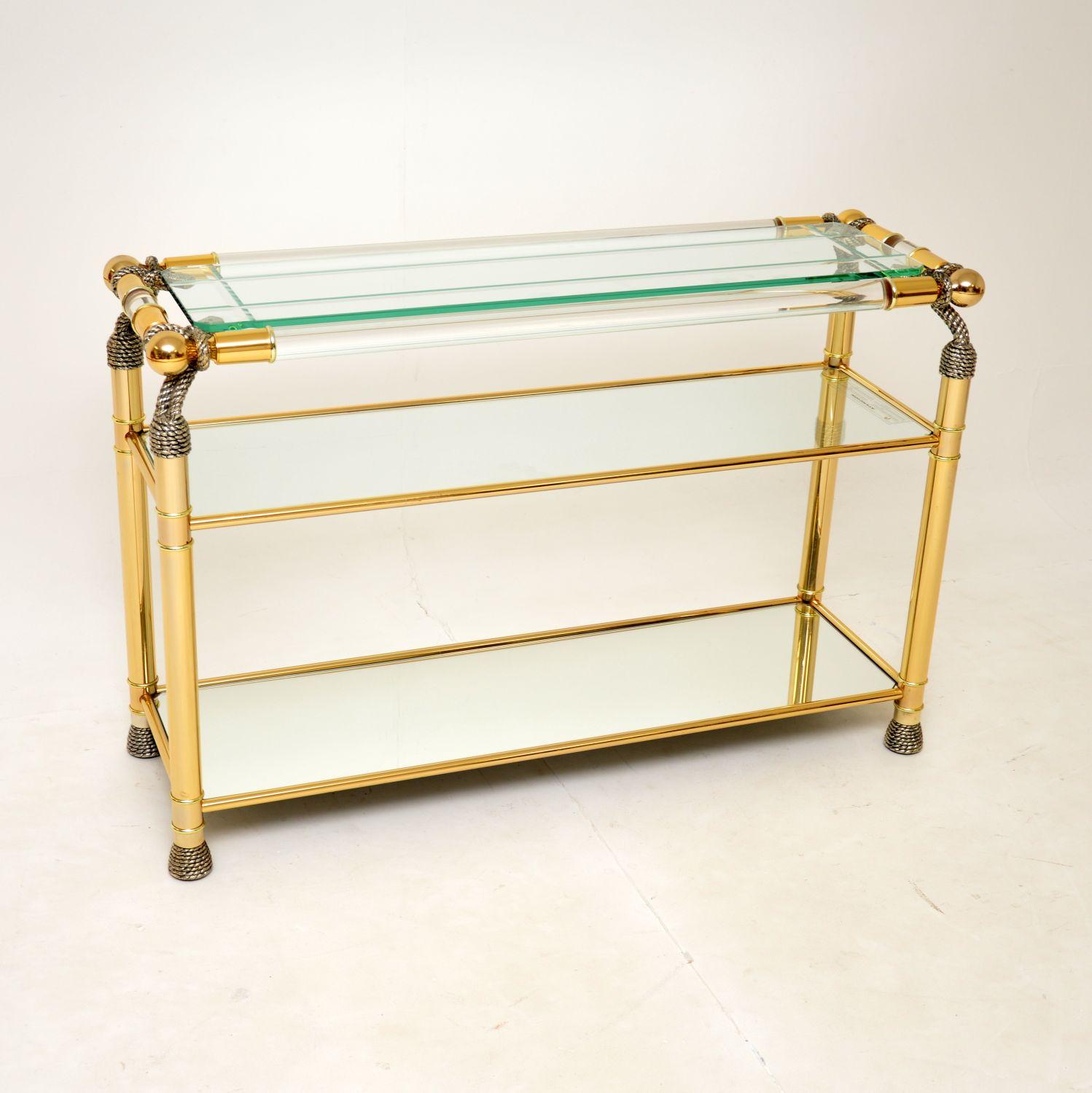 A beautiful and stylish vintage console table made by Curvasa in Spain, dating from the 1970’s.

It is of super quality and has a gorgeous design. The frame is clear lucite, with the legs and accents finished in gold and silver leaf. There are