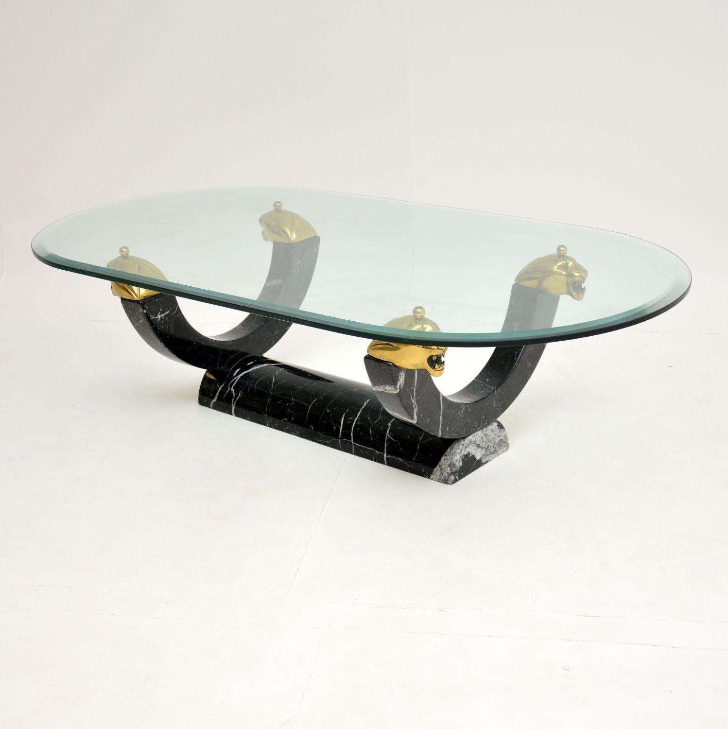 An impressive and very well made vintage coffee table, most likely made in Italy and dating from circa 1970s.

This has a fantastic solid marble base, which has a stunning shape and colour. The large, toughened oval glass top is supported by four