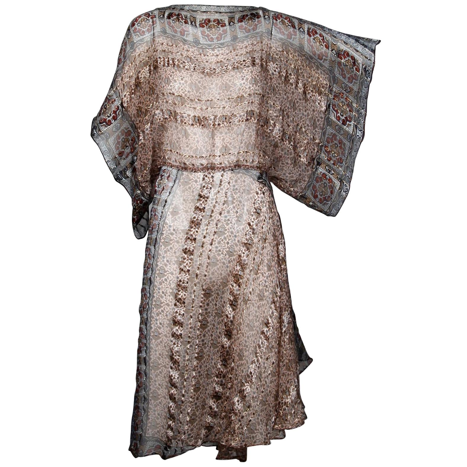 Gorgeous paper thin metallic printed silk dress with batwing sleeves by The Silk Farm. Unlined with rear button closure. 100% silk. The marked size is 6 and the dress fits like a size small-medium. The bust size is free, waist 32