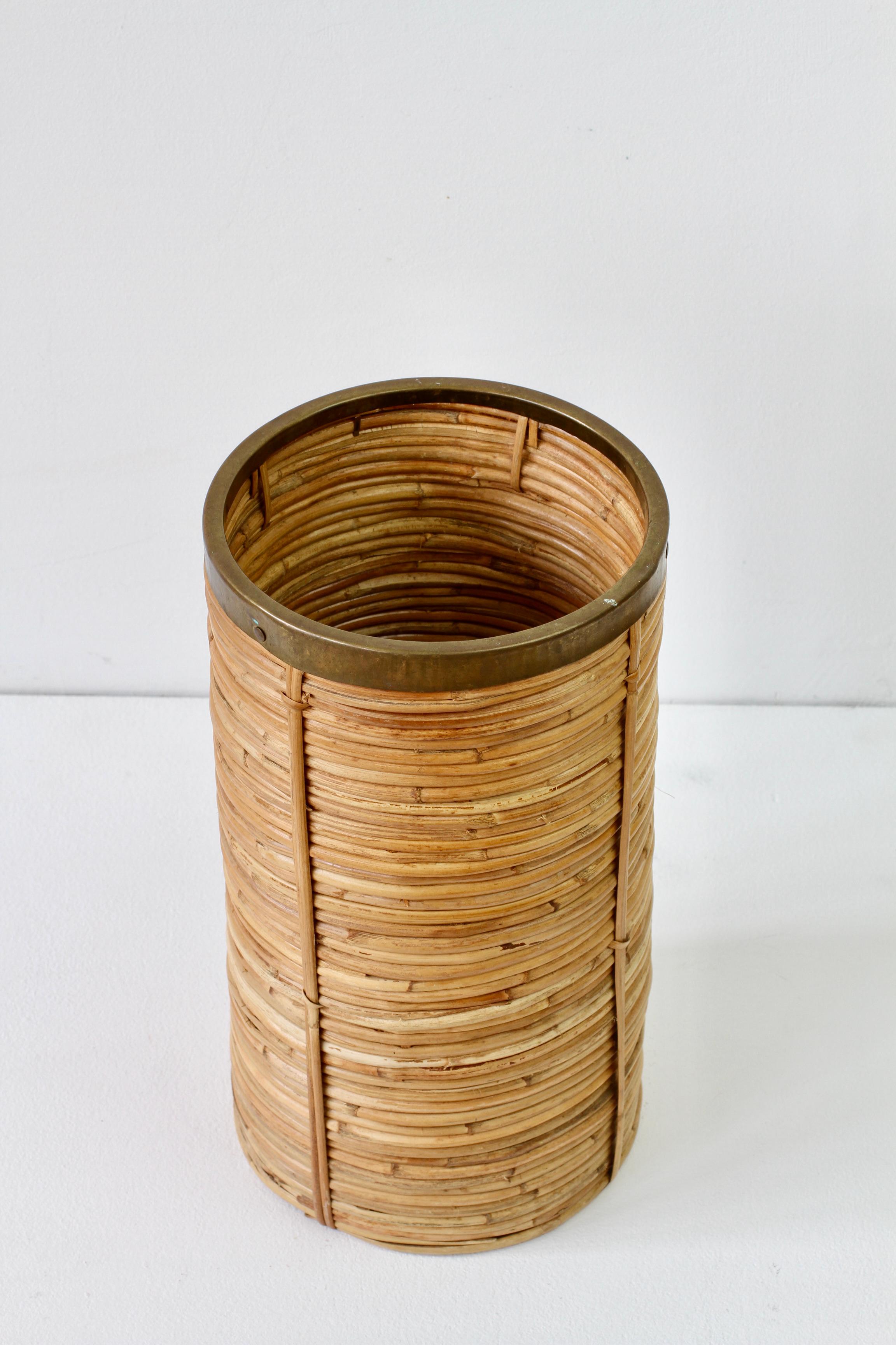 Midcentury Vintage Hollywood Regency style waste paper basket / bin or umbrella stand / walking stick holder made in Italy, circa 1970s. Made of bamboo and rattan with a patinated brass metal rim, which finishes the piece perfectly. A must have for