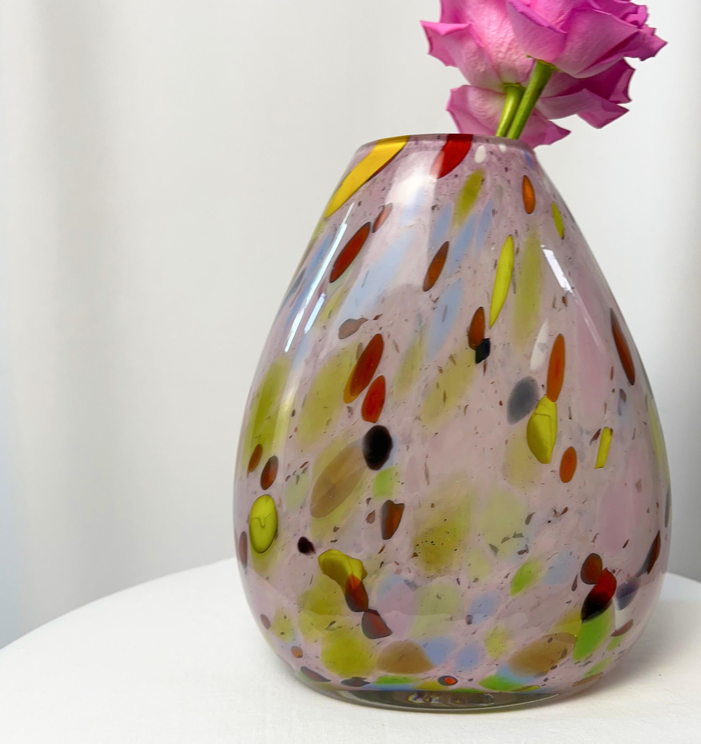 This luminous Murano teardrop vase, dappled with a confetti of colors, captures the vivacious spirit of the 1970s disco era. A testament to the revered glassmaking tradition of Murano, Italy, this piece, although from an unknown maker, is an