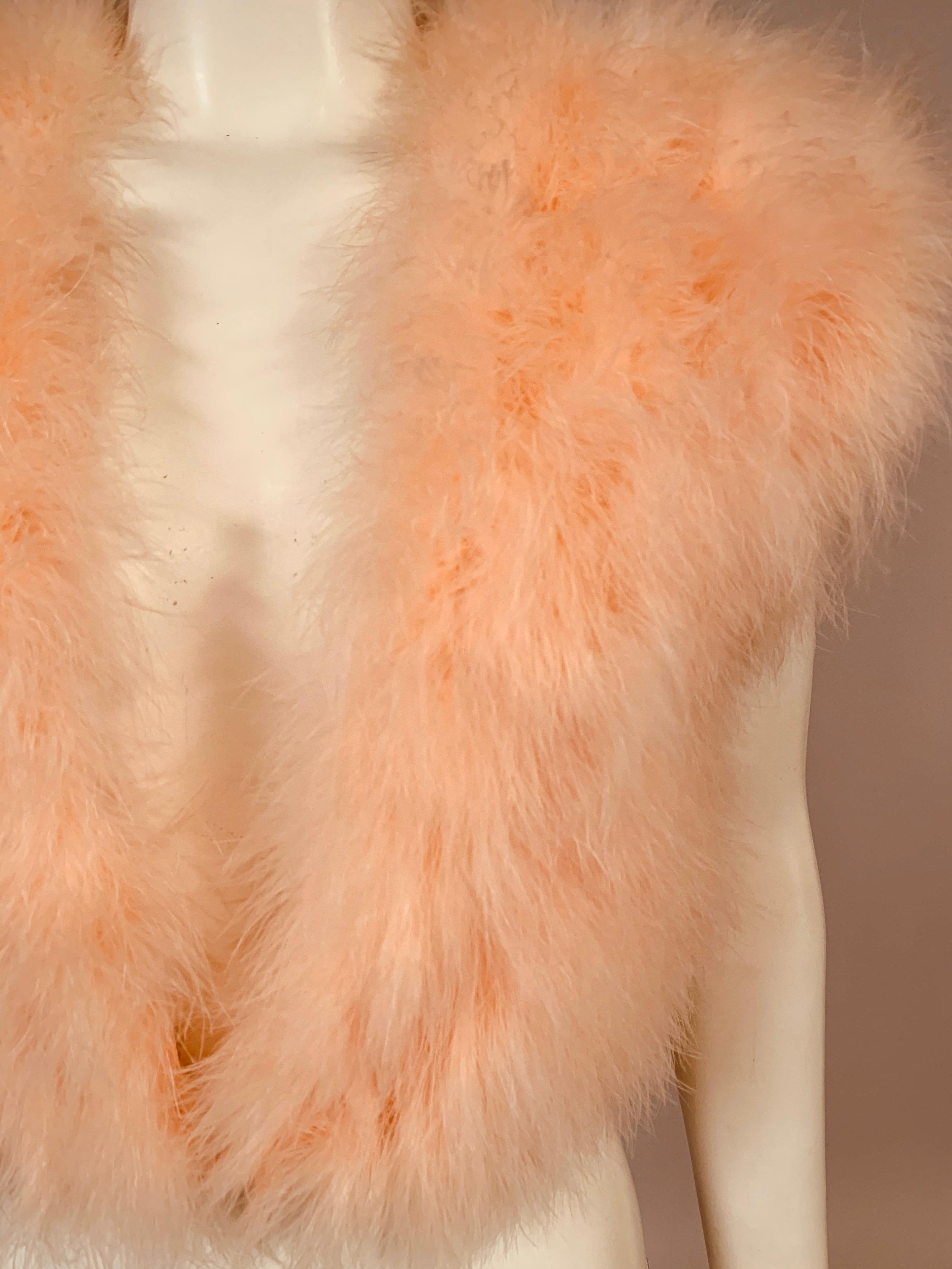 In pristine condition, this ultra feminine marabou feather vest appears to have been worn very little if at all.  The marabou is fluffy and bright and the peach satin lining is in excellent condition. The vest has a V shaped neckline with one fur