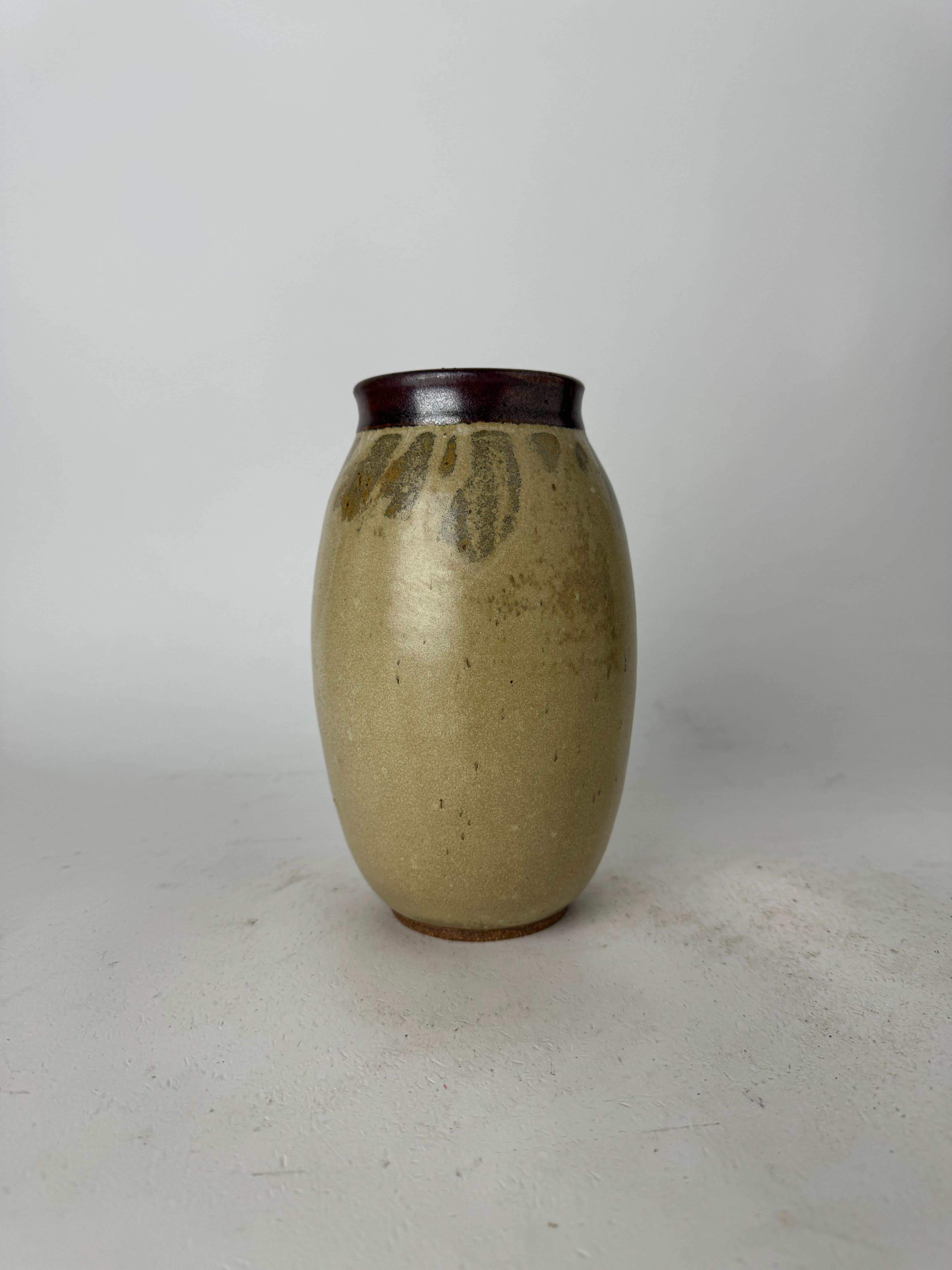 For sale, we present a captivating Vintage Hand-Thrown Studio Pottery Flower Vase, a true testament to craftsmanship and enduring beauty. Adorned in soothing shades of beige and brown, this vase is a statement piece that adds a touch of vintage