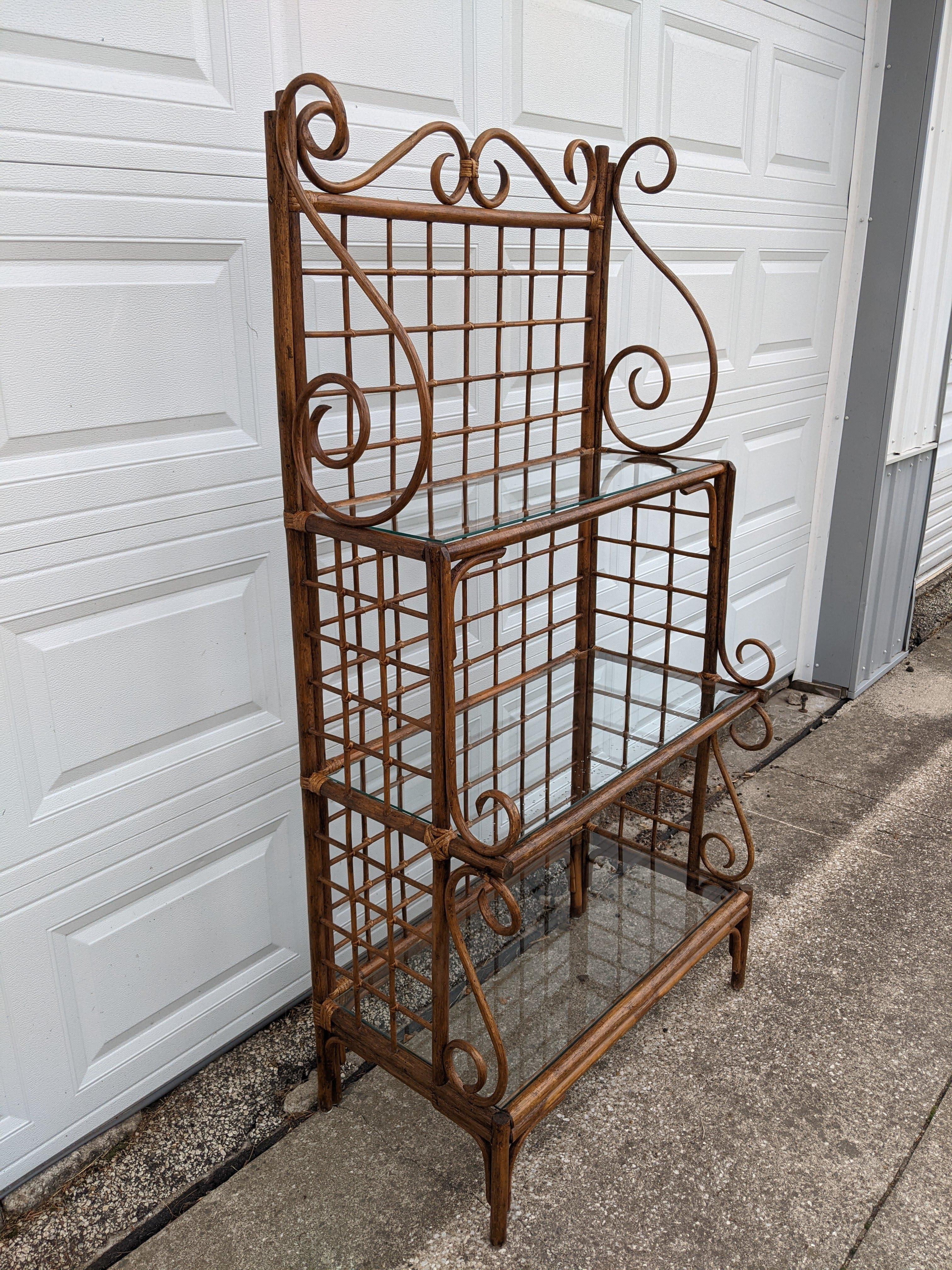 Nice vintage rattan display case or shelf, circa 1970s.

This piece has three glass shelves with varying sizes. Each shelf is 31.5 inches wide, with the top shelf being 11 inches deep, middle shelf 15 inches deeps, and bottom shelf 16 inches