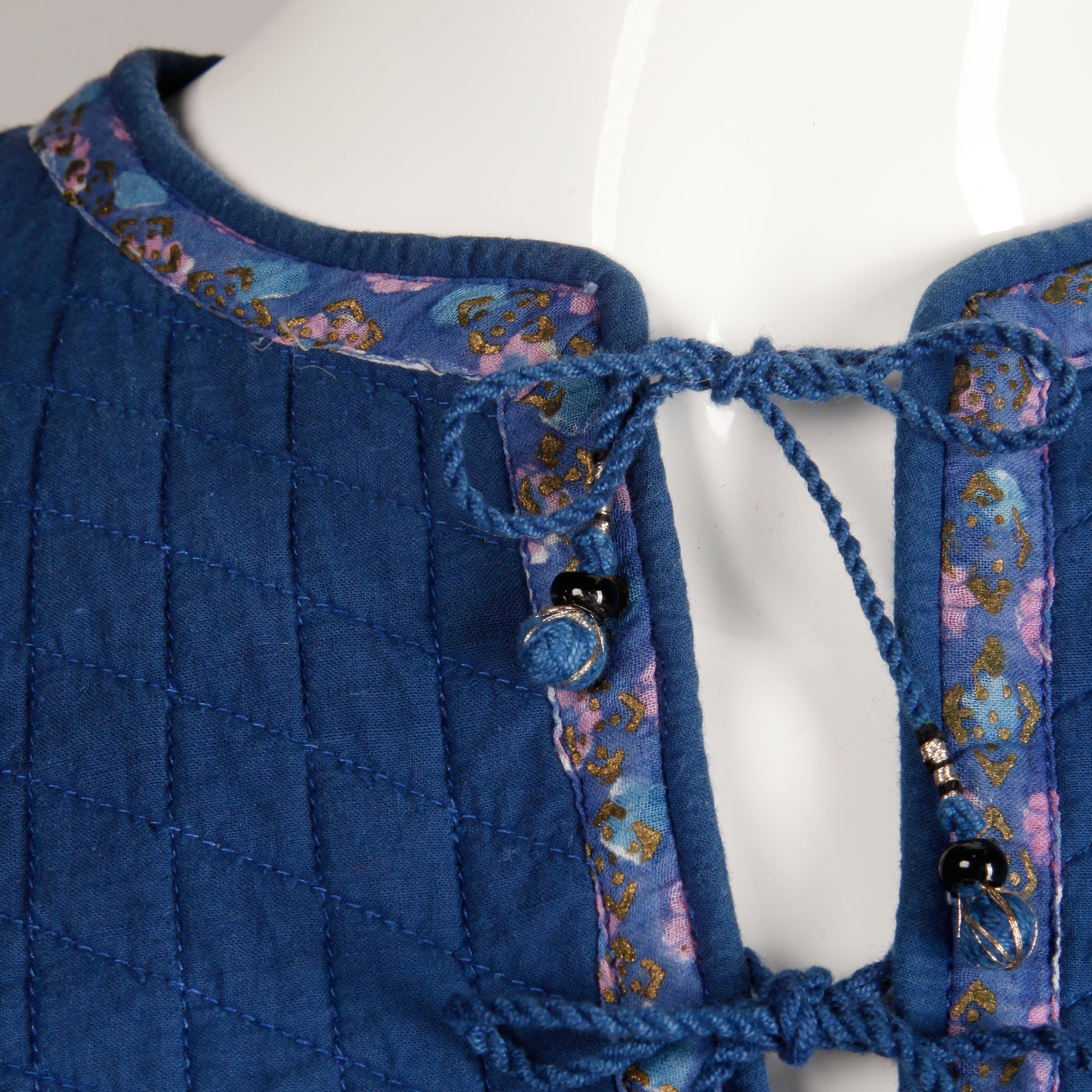 Paper thin vintage 1970s cotton gauze dress in a blue floral Indian block print. Unlined with front tie closure. High low hem. The marked size is small. 100% cotton. The bust measures 36