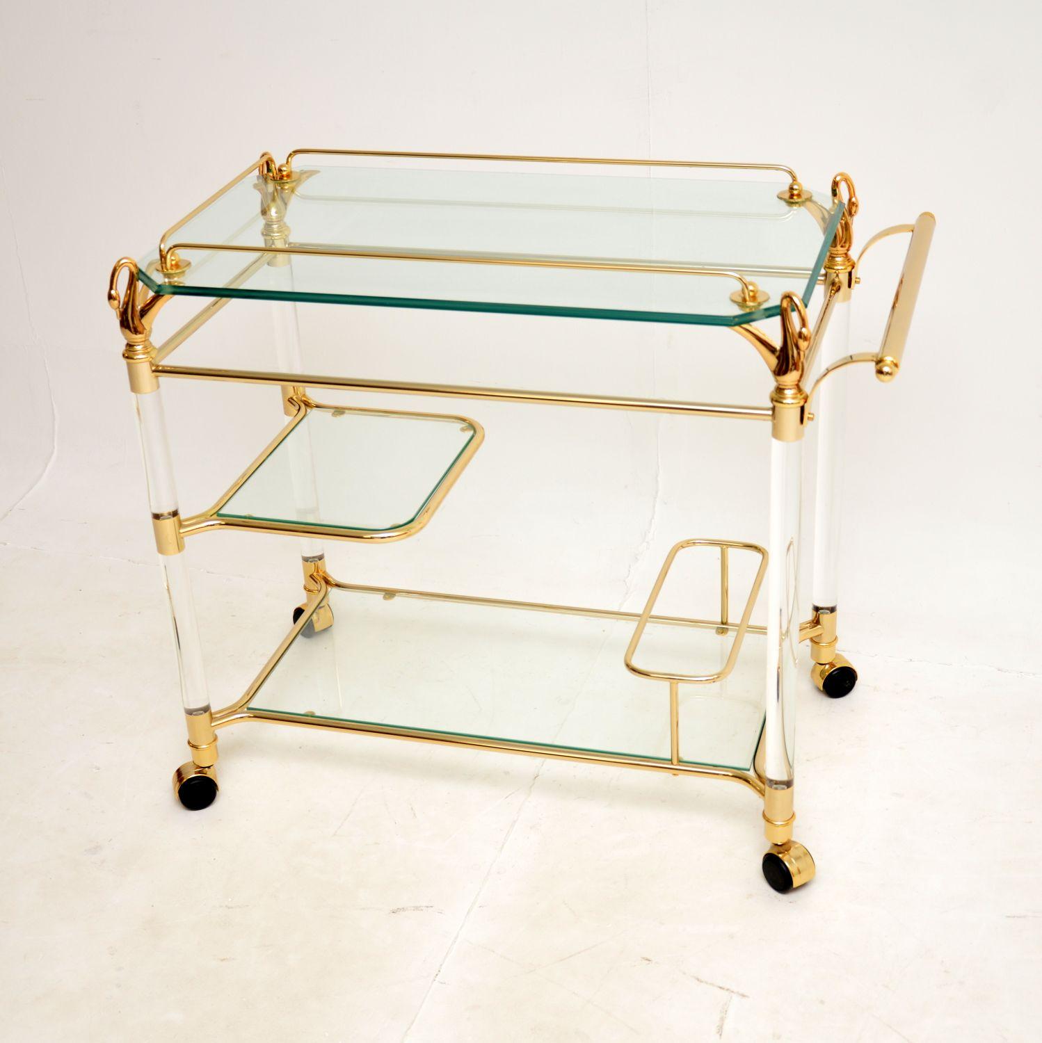 An absolutely stunning and very impressive vintage Hollywood Regency style drinks trolley. This was made in Spain, it dates from the 1970s-1980s.

The quality is outstanding, this has a clear lucite frame with gold plated fixtures. The top surface