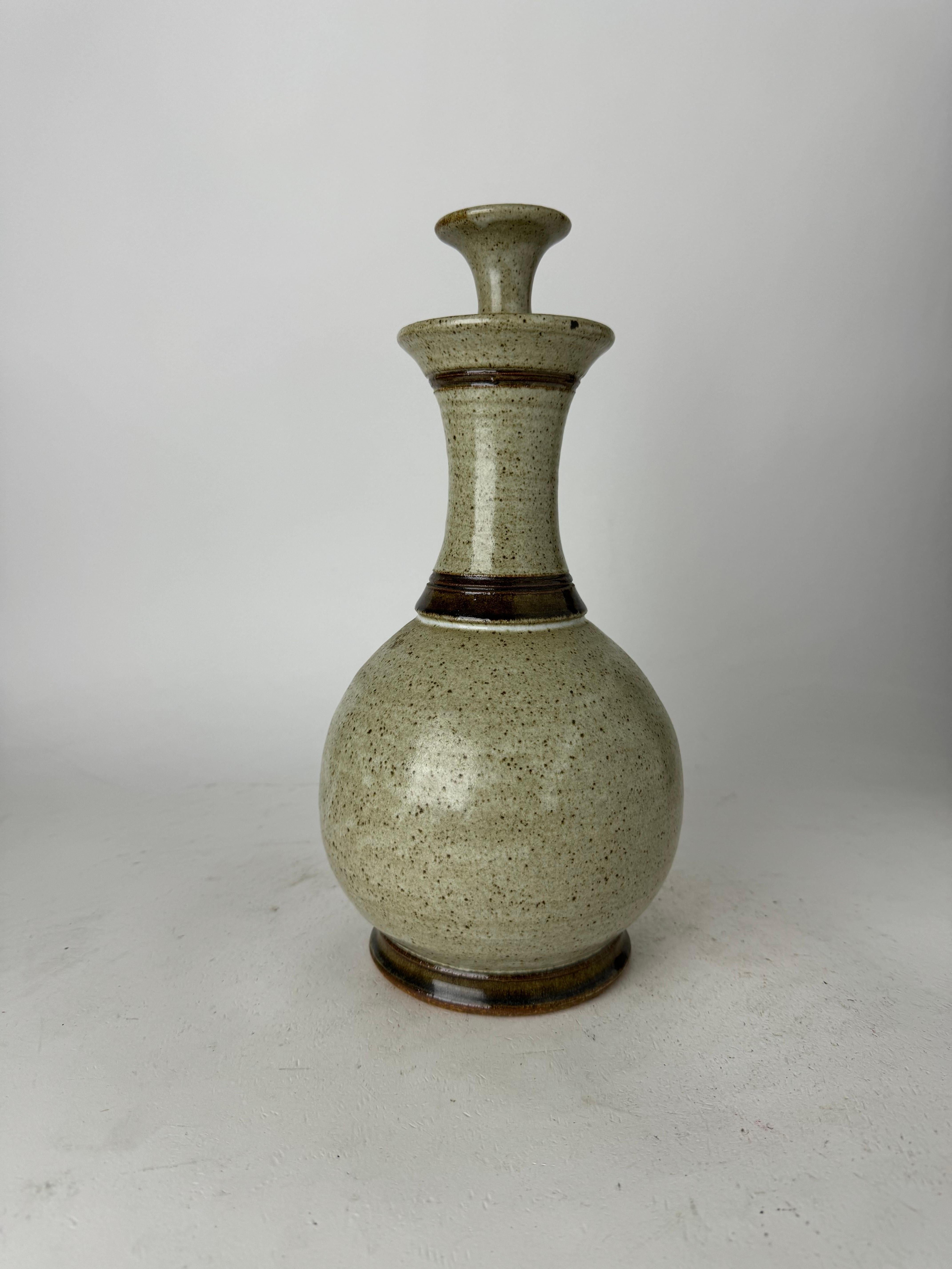 Explore the timeless beauty of our exquisite Vintage Hand-Crafted Pottery Bottle, a unique blend of artistry and sophistication. Crafted in earthy tones of beige and brown with a mesmerizing speckled design, this bottle is a true testament to