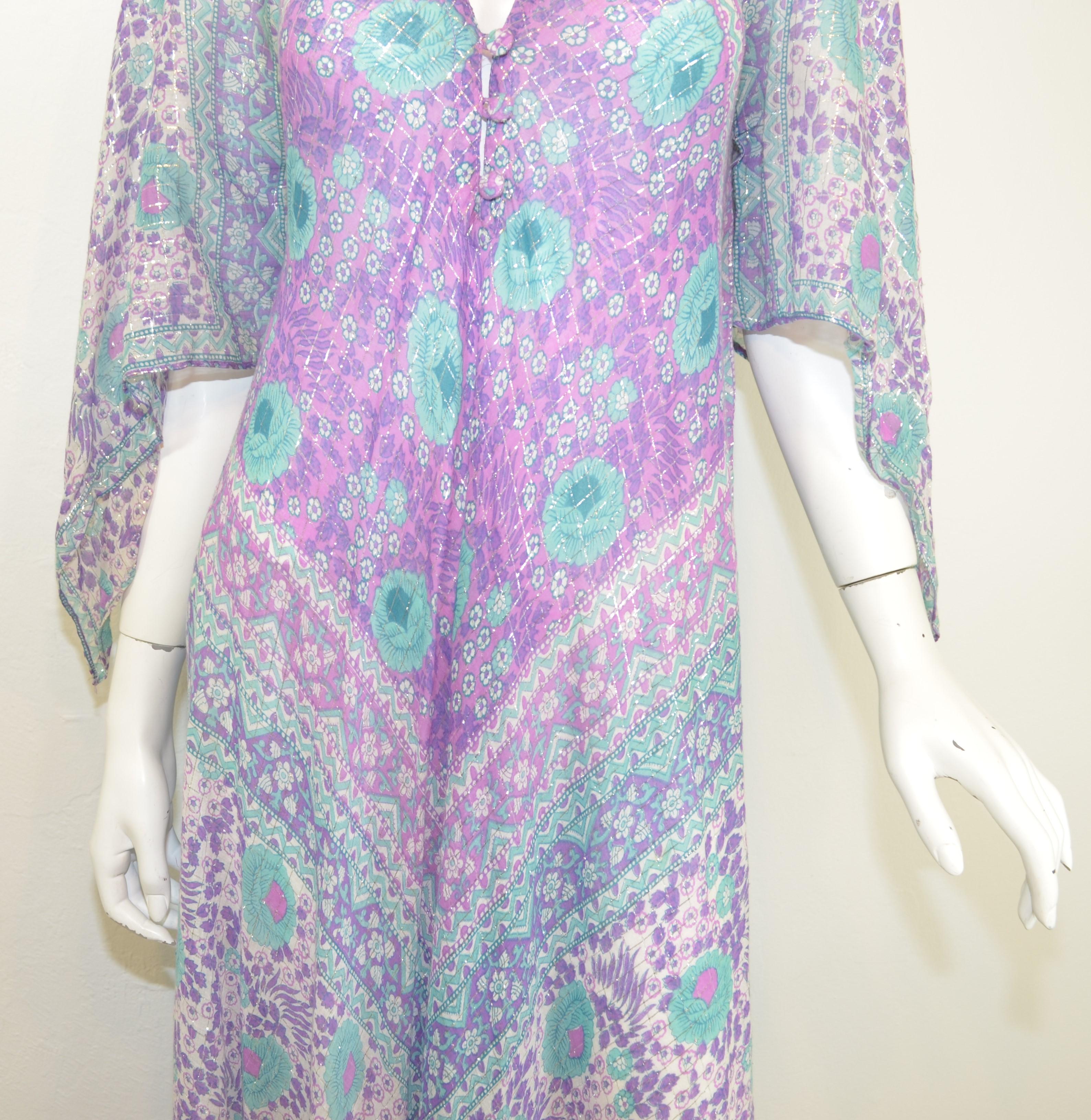 Sultana vintage Boho Indian caftan dress featured in a light blue and lavender with silver metallic threading, three buttons at the bust, and asymmetric cut sleeves. Dress is composed with 92% cotton, 8% metallic and made in India. Labeled as One