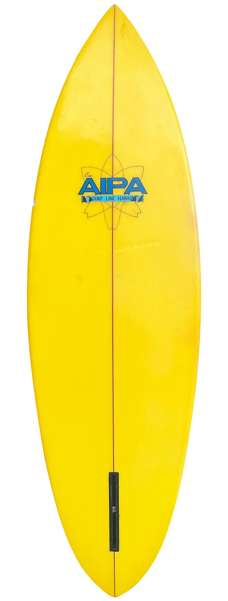 1977 vintage Surf Line Hawaii surfboard made by the late Ben Aipa (1942-2021). Features a gorgeous yellow tinted bottom/wrap around rails with double pin line design and single fin box setup. A remarkably well cared for example of a rare 1970s Surf