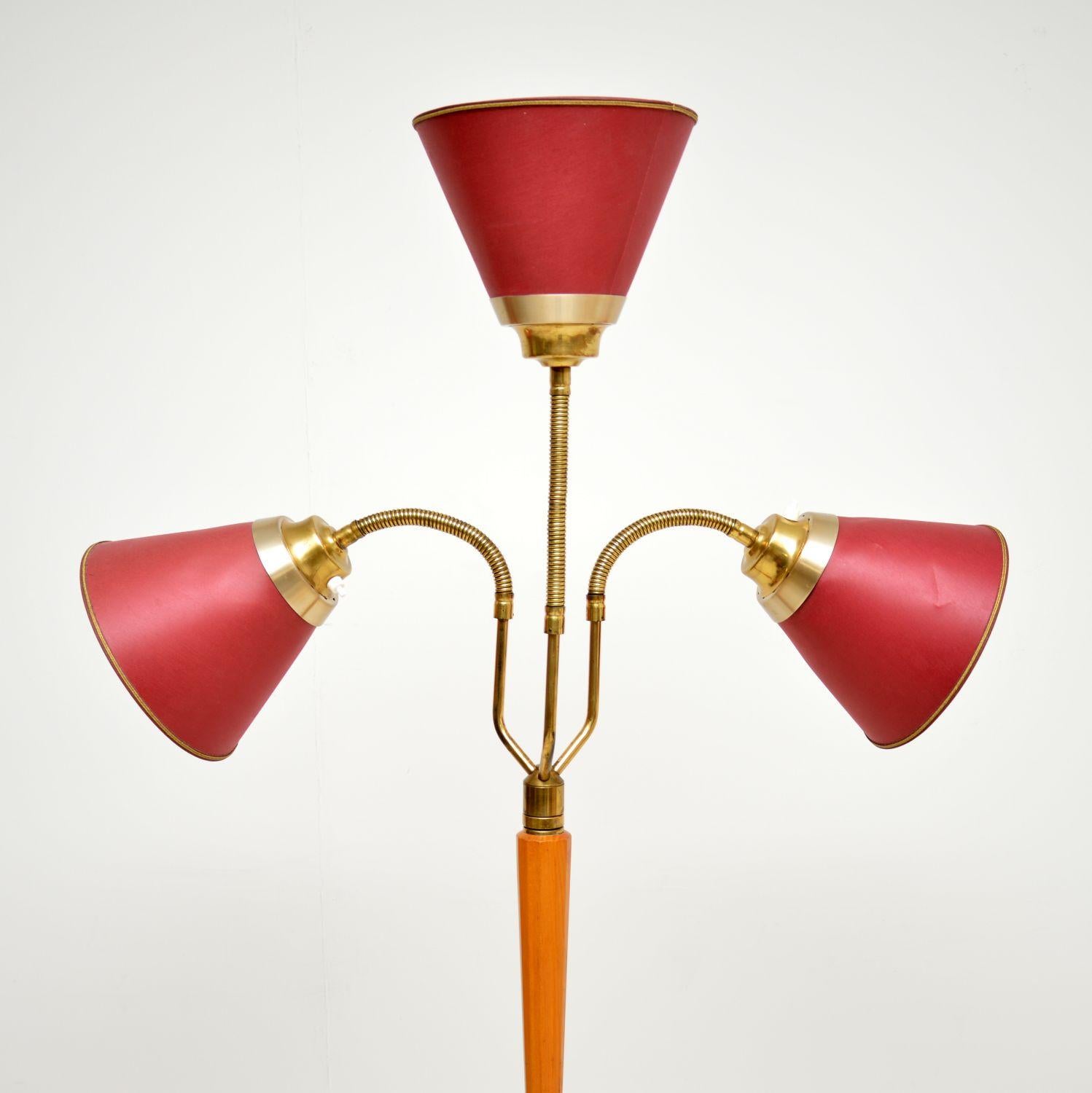 Una splendida lampada da terra vintage a tre teste, importata di recente dalla Svezia e risalente agli anni Settanta.

La struttura in ottone poggia su una base in metallo nero e ha una colonna centrale in noce. Le tre teste della lampada hanno
