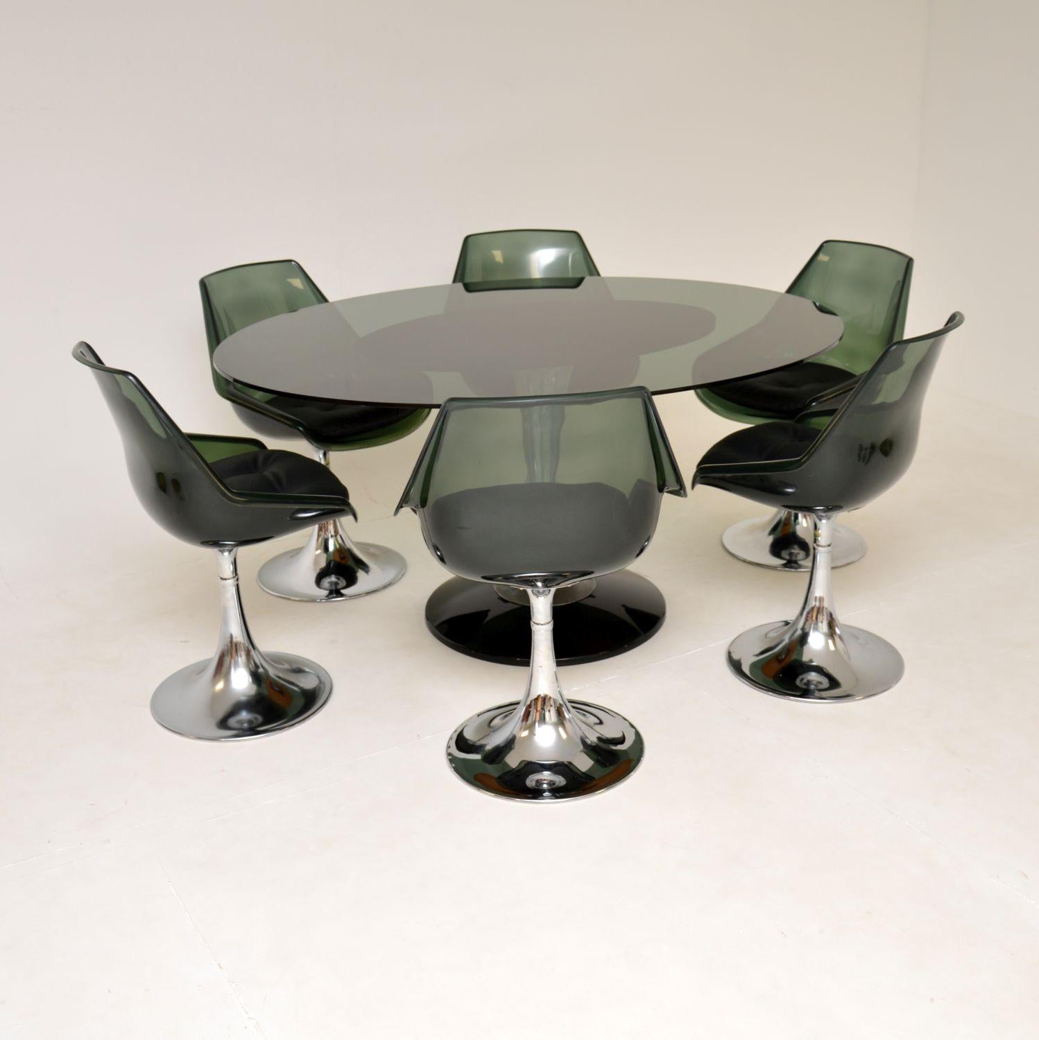 A stunning and rare vintage dining table and chairs by American company Chromcraft. This was made in the USA and dates from the 1970’s.
It is of amazing quality, with such a stylish design. The table has a thick smoked oval shaped glass top that