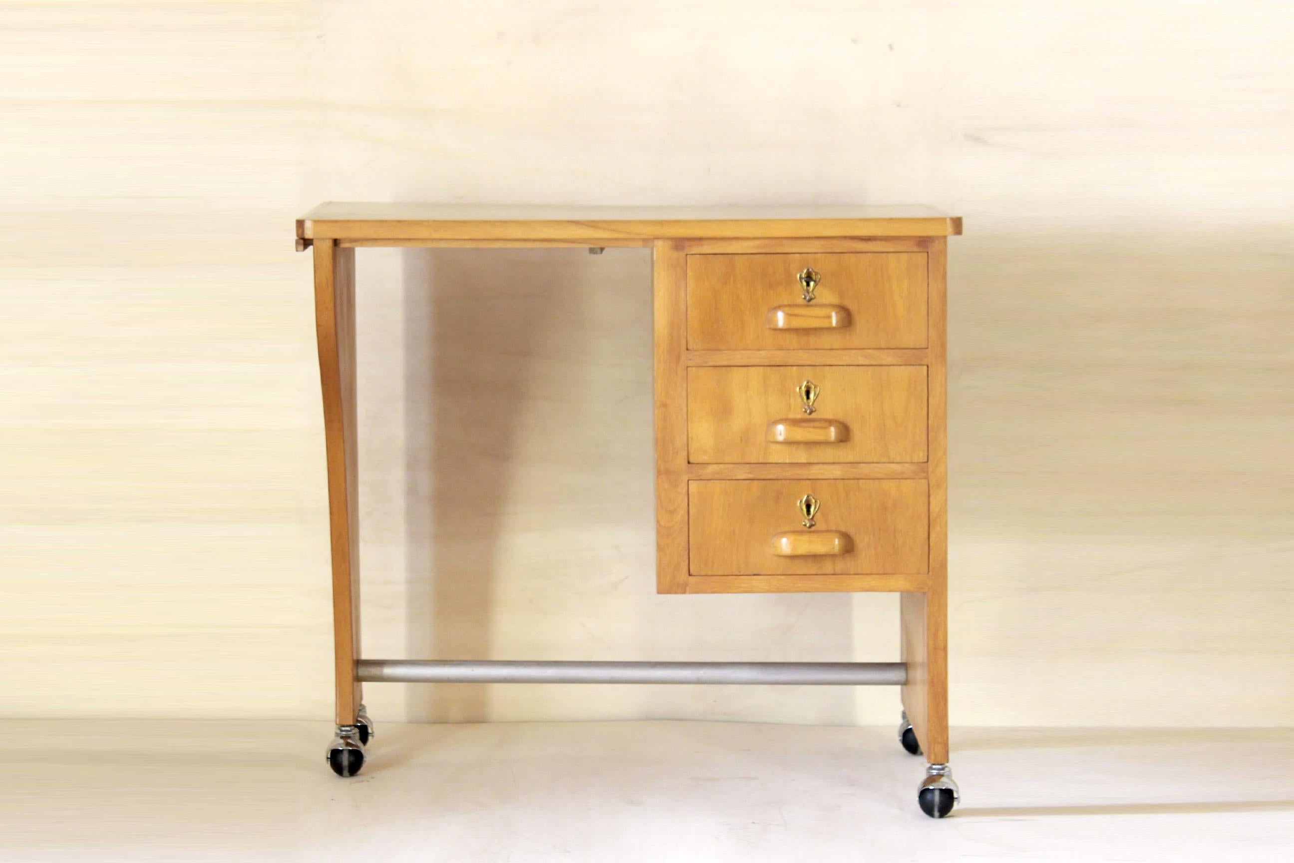 Vintage rolling Wood Desk Table, Italy 1970s.
A solid cherry wood bright rolling writing desk from the 1960s in pure midcentury style. The item is in very good conditions as the wood has been cleaned and polished and original small wheel have been