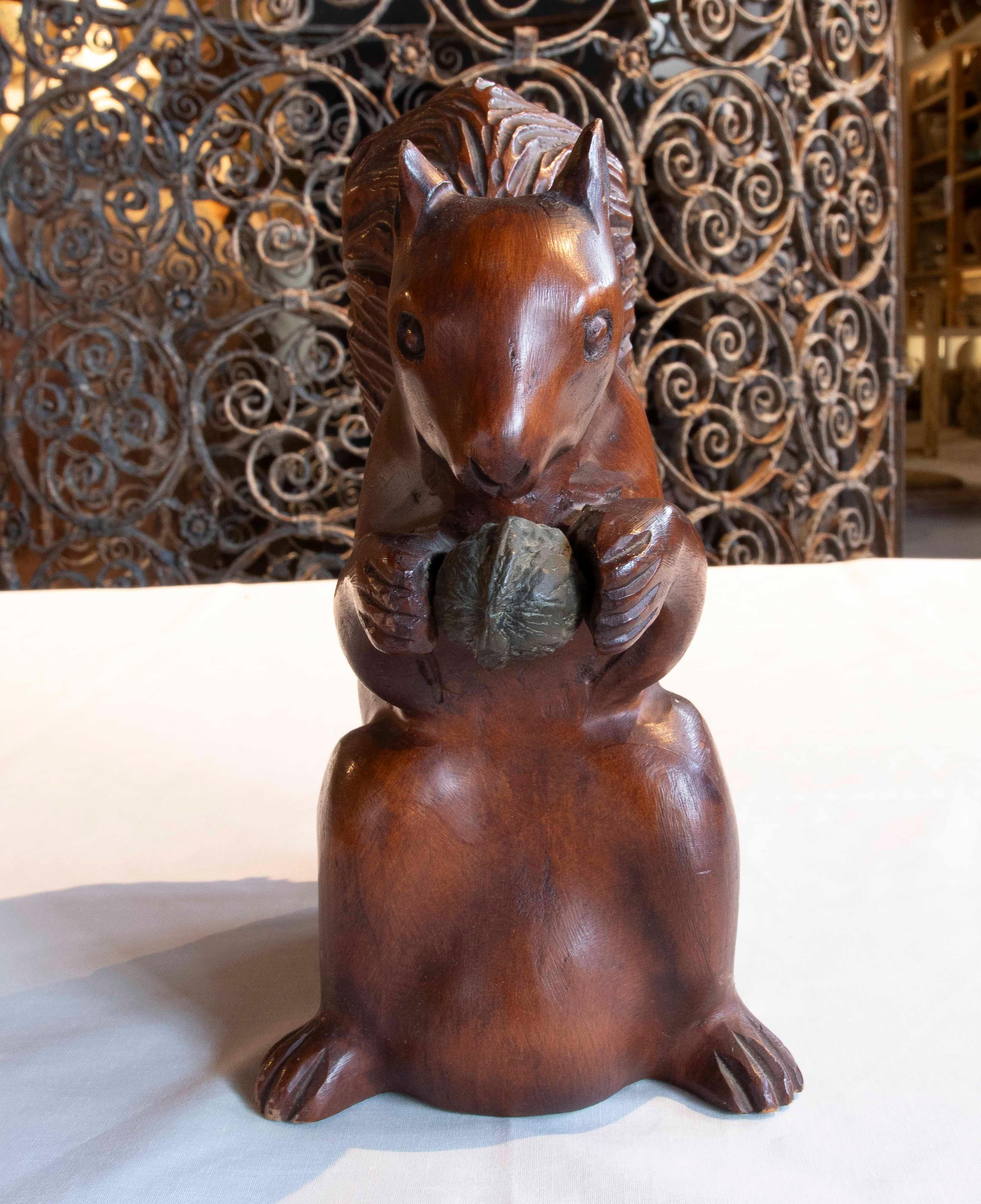 Affascinante scultura di scoiattolo intagliata a mano in legno massiccio, realizzata in Europa a metà del XX secolo. Il pezzo presenta una figura modellata con cura, con linee morbide e una finitura calda che mette in risalto le venature naturali