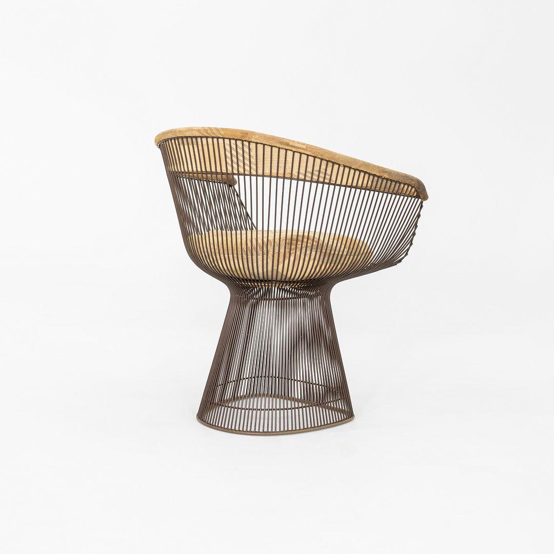 Il s'agit d'un fauteuil Platner, modèle 1725, conçu par Warren Platner pour Knoll en 1966. Cet exemple date des années 1970. La structure de la chaise est composée d'acier bronzé patiné, et l'assise et le dossier sont recouverts d'un tissu à