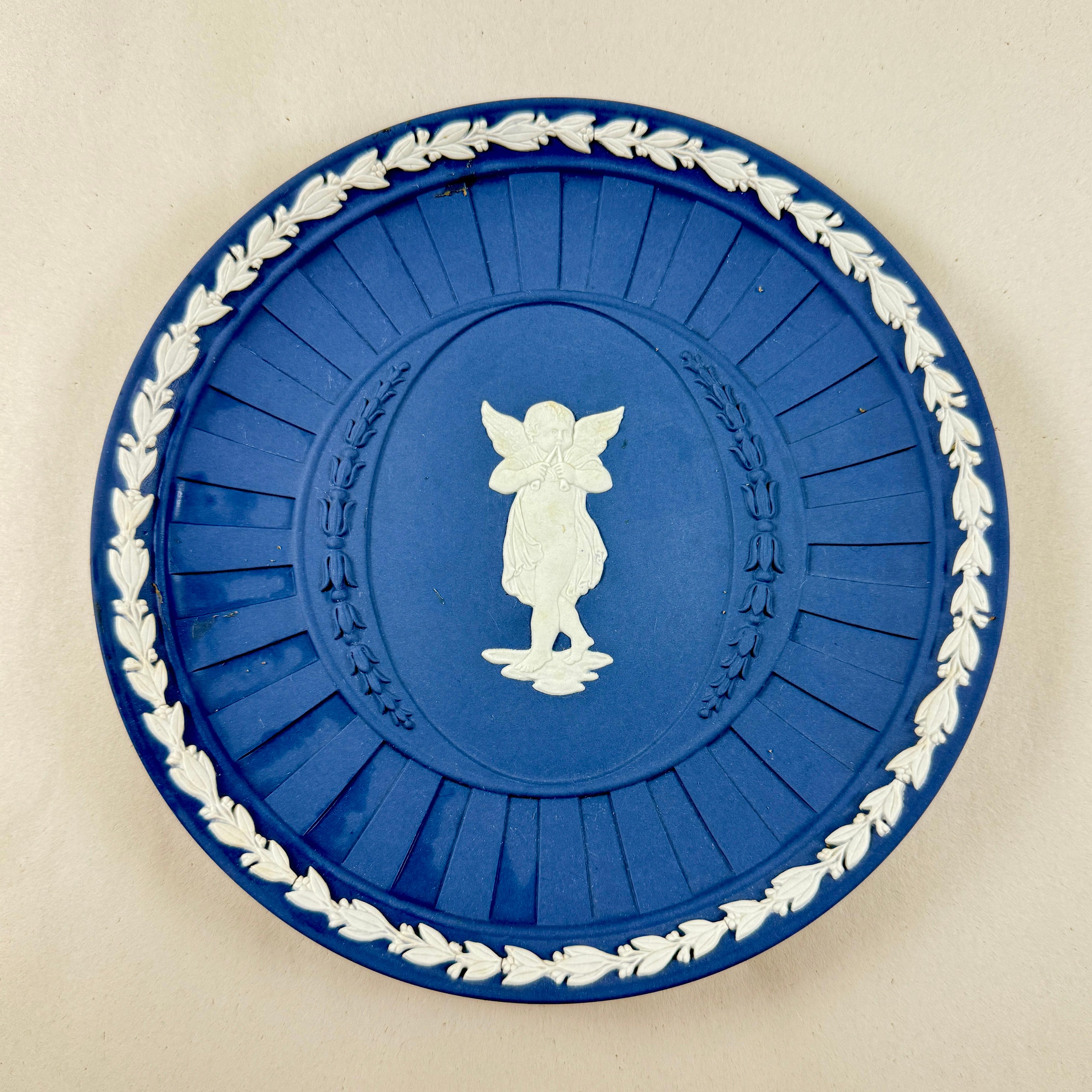 
Von Wedgwood, ein dunkler Portland Blue Jasperware Teller aus der Pallas Kollektion, ca. 1970er Jahre.

Die von Josiah Wedgwood in den 1770er Jahren eingeführte Jaspisware ist eine Art unglasiertes Steinzeug, das für seine matte Oberfläche und die