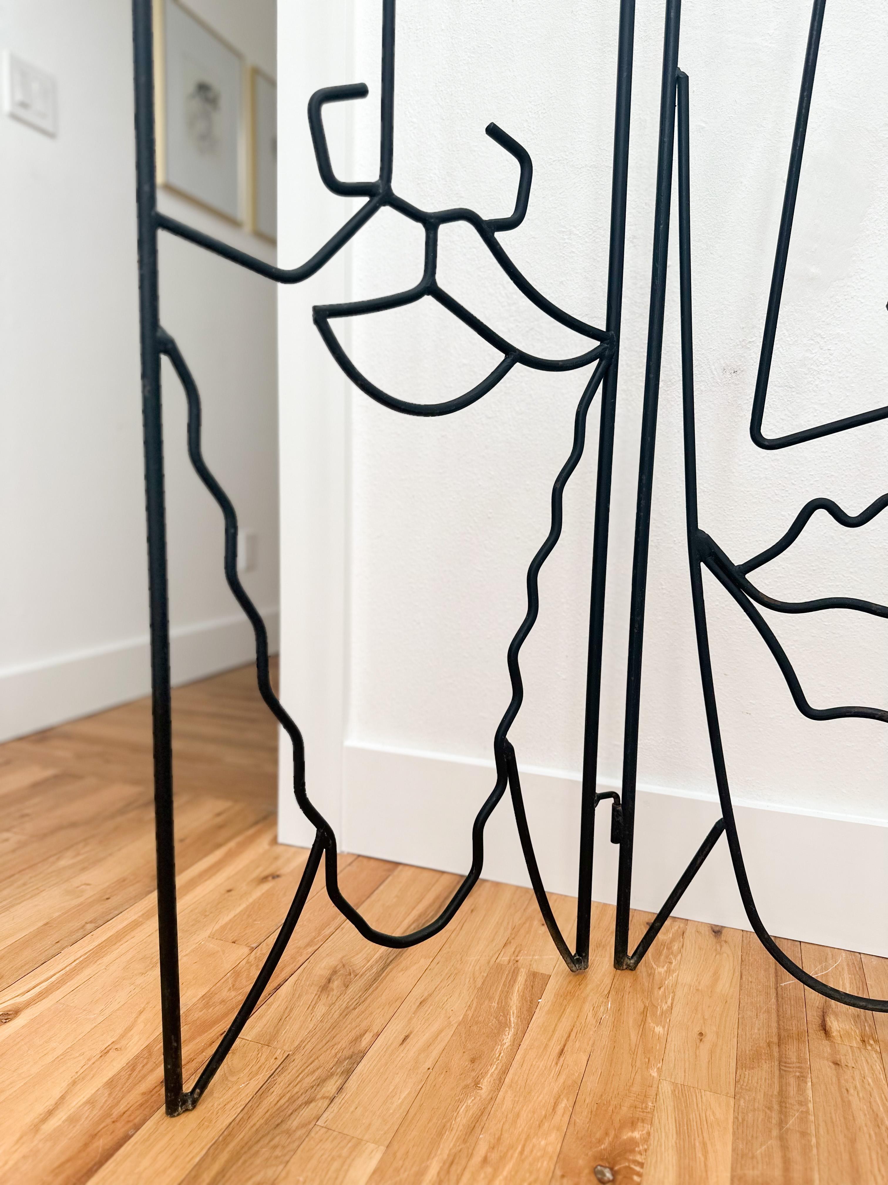 Whimsical sculptural room divider screen in the style of metal artist John Risley, c.1970s. Three enameled steel rod panels depict a man and two women, an enigmatic power throuple with long noses and pillowy lips. Risley's figurative welded designs