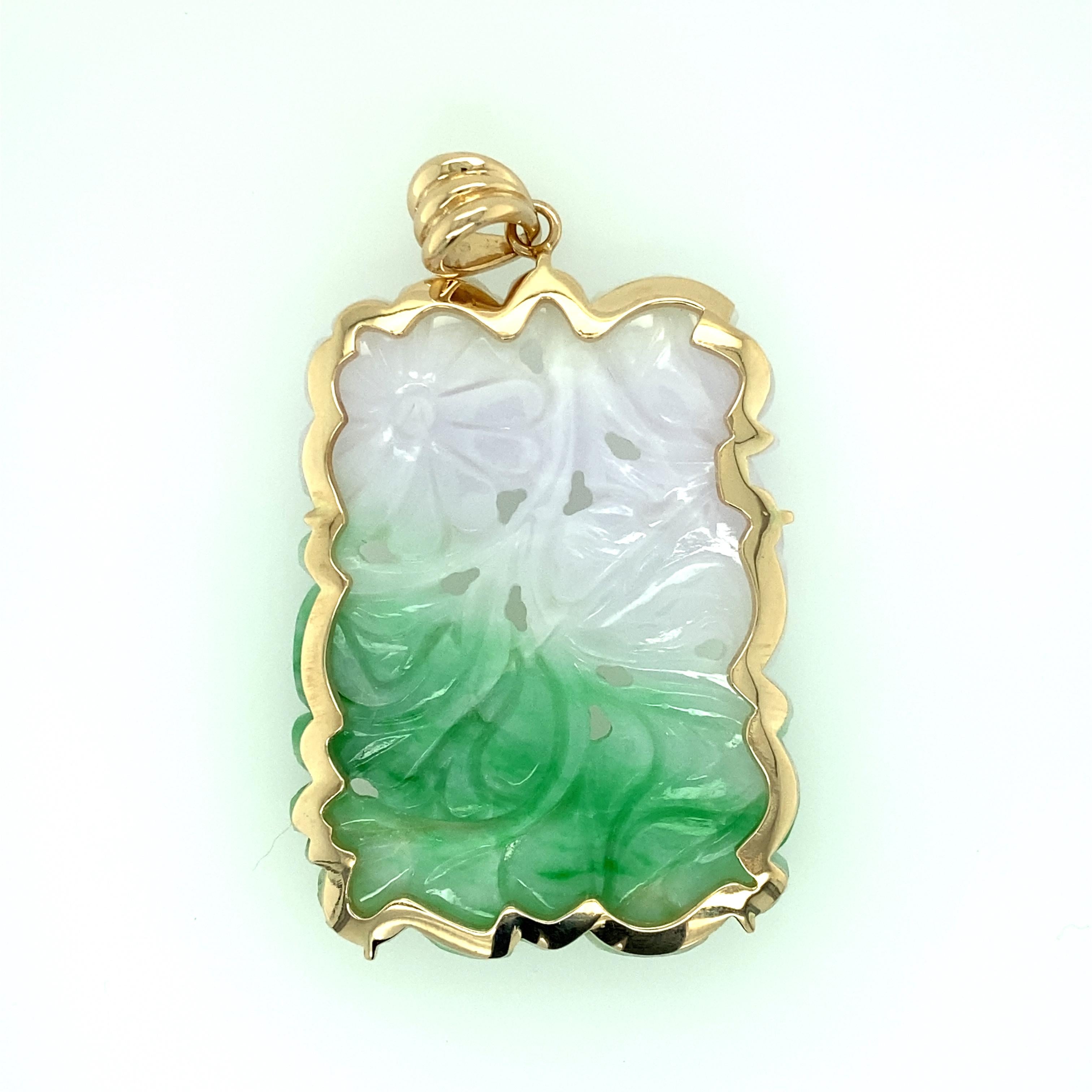 One 14 karat yellow gold (stamped 14K) estate white and green carved flower motif  jadeite pendant. The pendant measures 2 inches long and 1.5 inches wide.