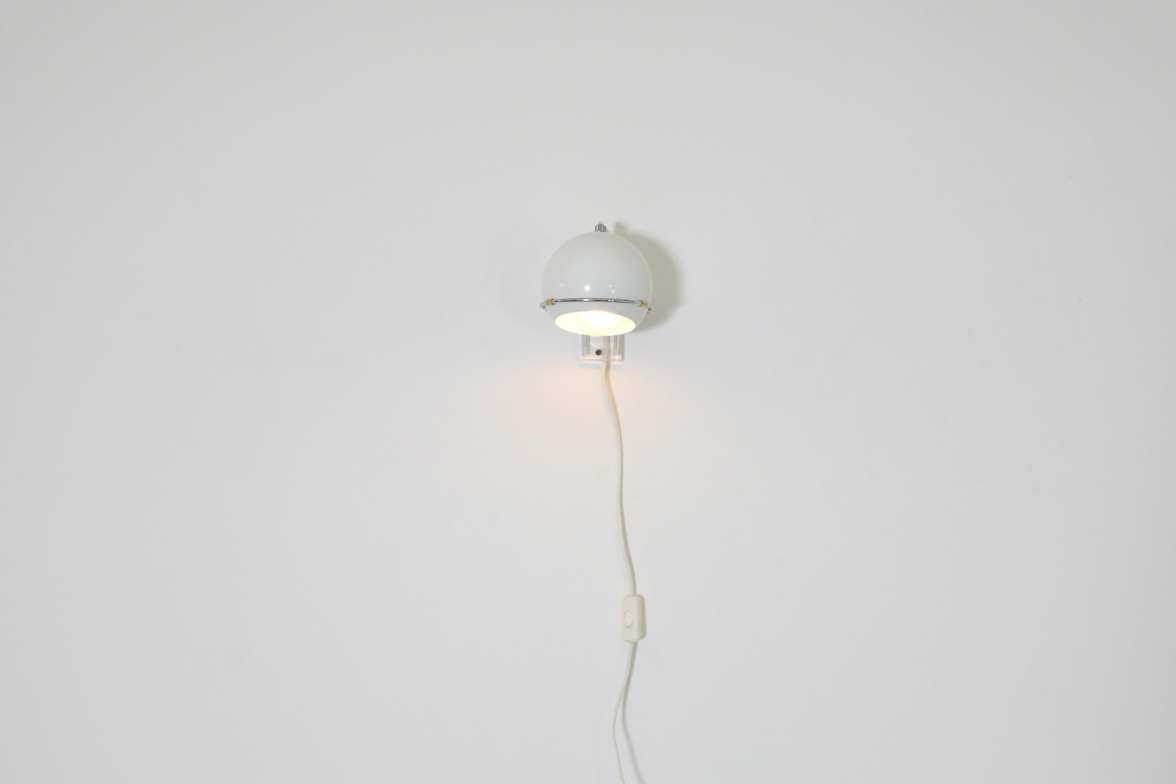 Mid-Century white enameled metal globe spot light sconce with chrome ring holder and plexi back mount by Gepo. This modern styled Dutch spot lamp is multi-directional and ideal in a fun and energetic office or bedroom space. In original condition