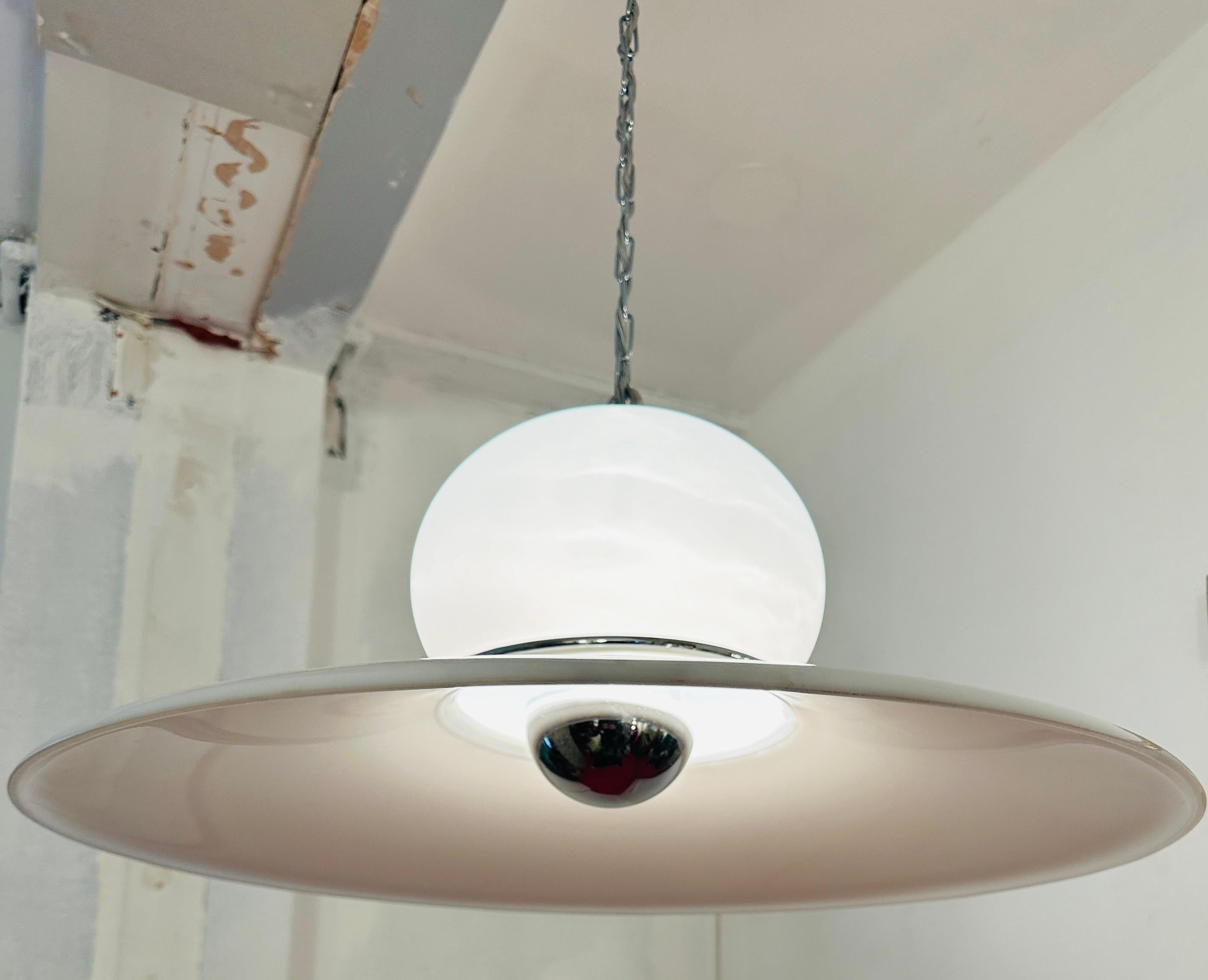 1970s white plexiglass with chrome detailing UFO shaped hanging pendant light which was designed by Harvey Guzzini. The original coiled wire and ceiling fitting was in poor condition and very discoloured being over 50 years old.  I have therefore
