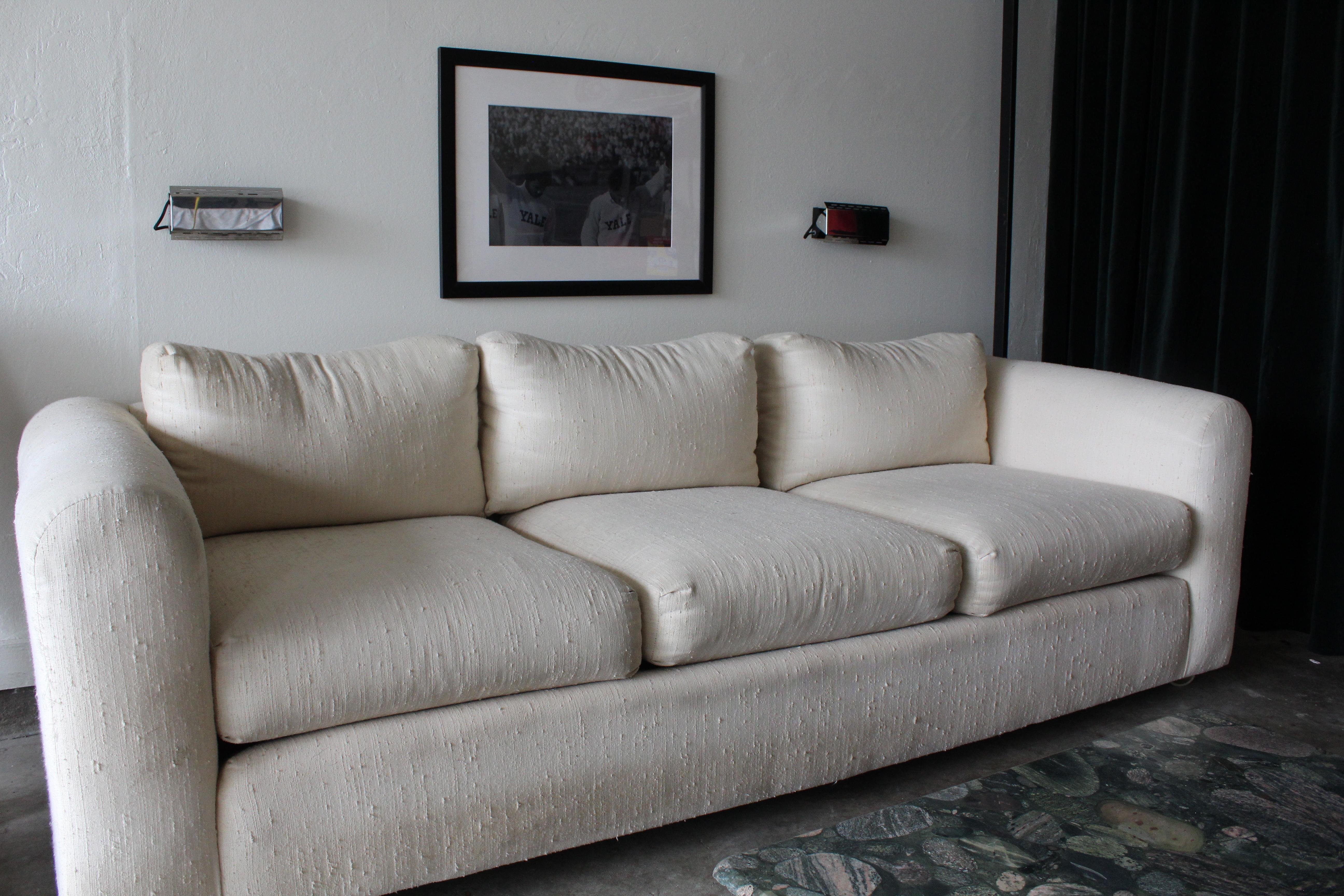 Ce superbe canapé Selig Monroe des années 1970. Cette belle pièce danoise comporte trois coussins de dossier et trois coussins d'assise sur un cadre rectangulaire avec des accoudoirs arrondis. L'ensemble de la pièce est tapissé d'un tissu blanc qui