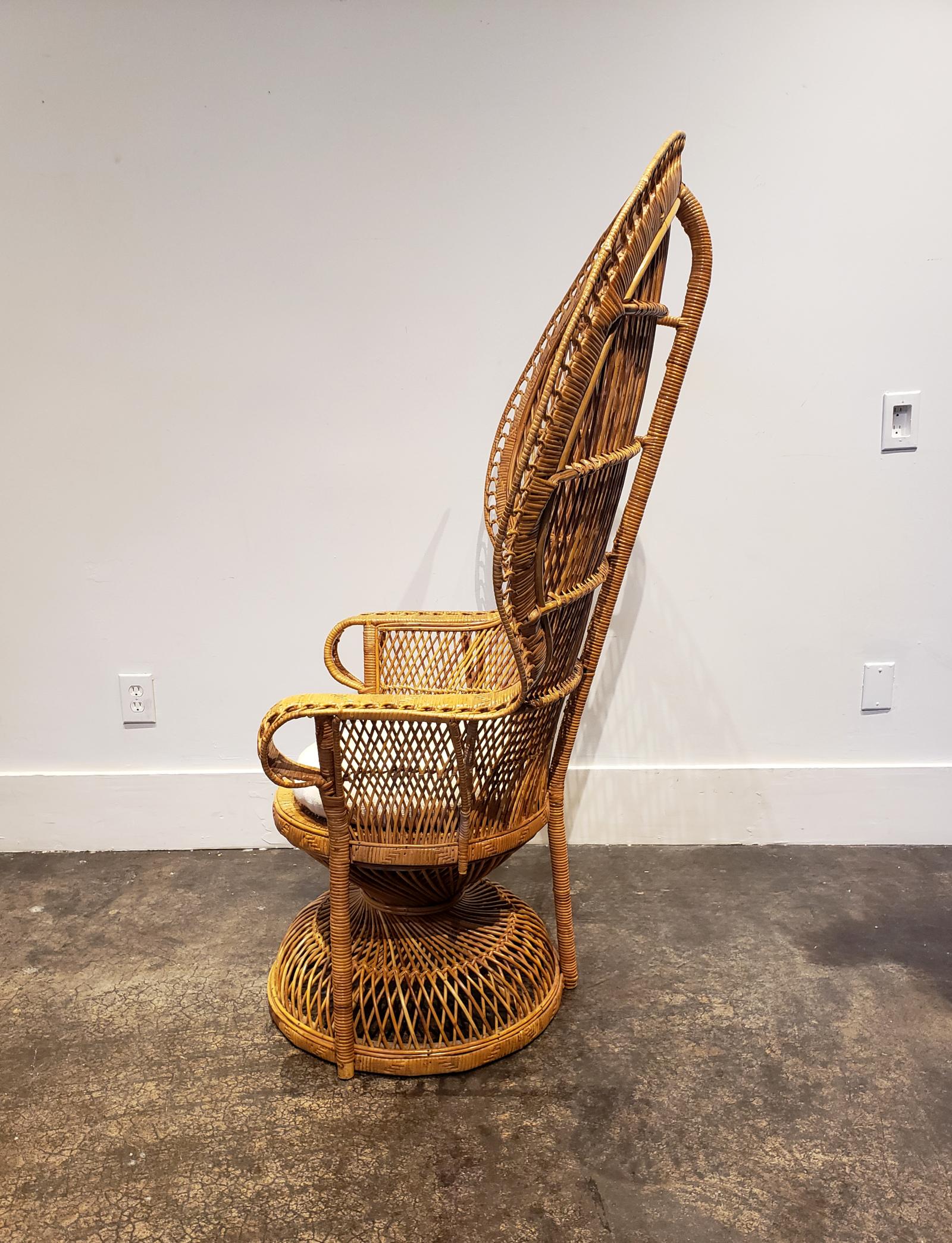 Iconic 1960s-1970s peacock chair made of woven rattan. Comes with comfy home-made white cushion.
  