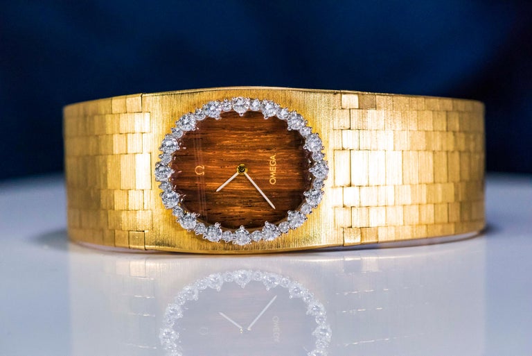 Omega, montre-bracelet jonc large en or jaune 18 carats avec cadran en bois  de teck et diamants, années 1970 En vente sur 1stDibs