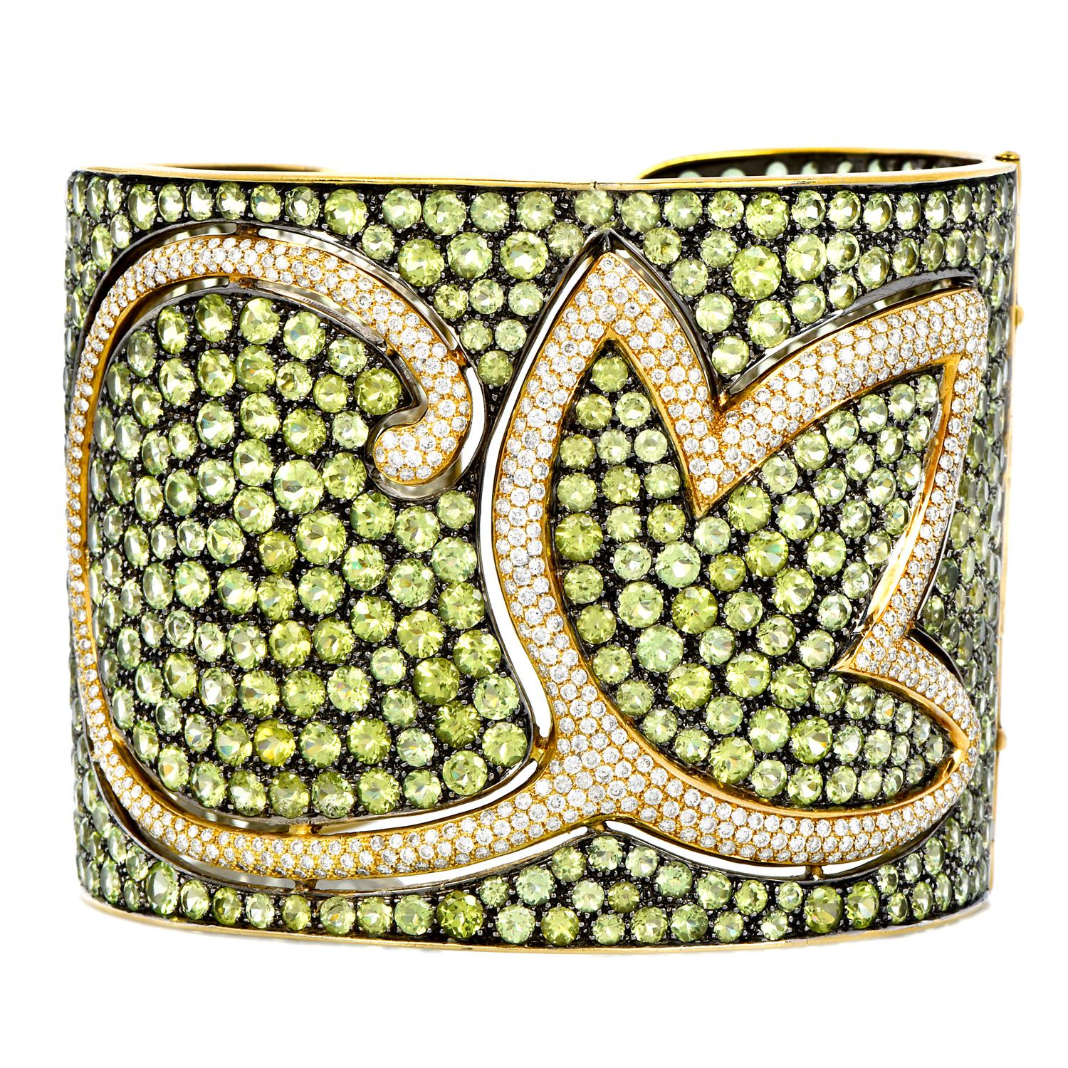 A finely made gold wide-cuff bangle bracelet, with timeless elegance, and a royalty-inspired look.

This wide cuff bracelet is crafted in solid 18K white and yellow gold. it is covered all around with genuine round cut peridot and very fine