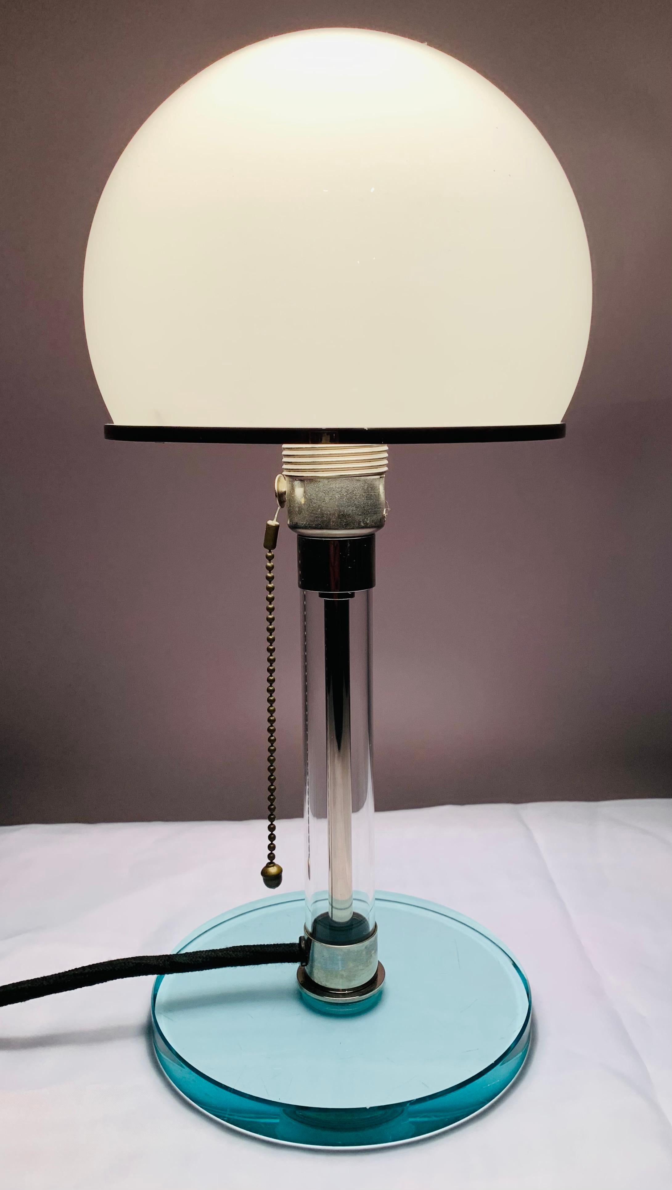 1970s White opal glass domed shade table lamp originally designed by Wilhelm Wagenfeld in Germany during 1924. Model WG 24. The lamp originates from an early reproduction by Tecnolumen in the 1970s. The glass shade is held onto the chrome-plated