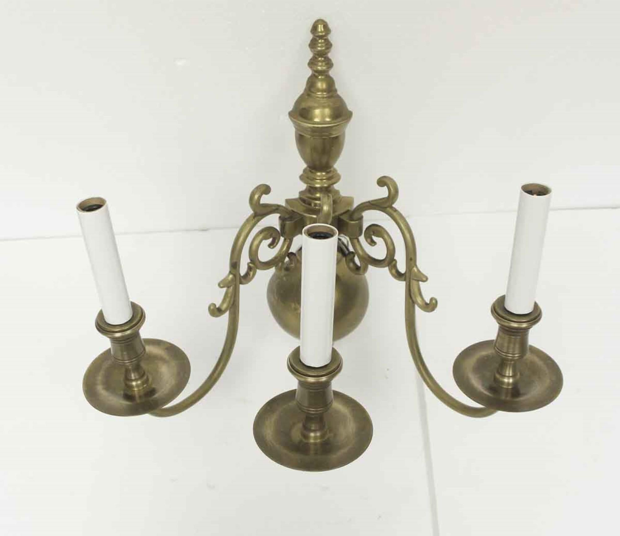 1970s 3 arm wall sconce done in the Williamsburg style. Made of cast brass. Uses candelabra bulbs. Cleaned and rewired. Small quantity available at time of posting. Priced each. Please inquire. Please note, this item is located in our Scranton, PA