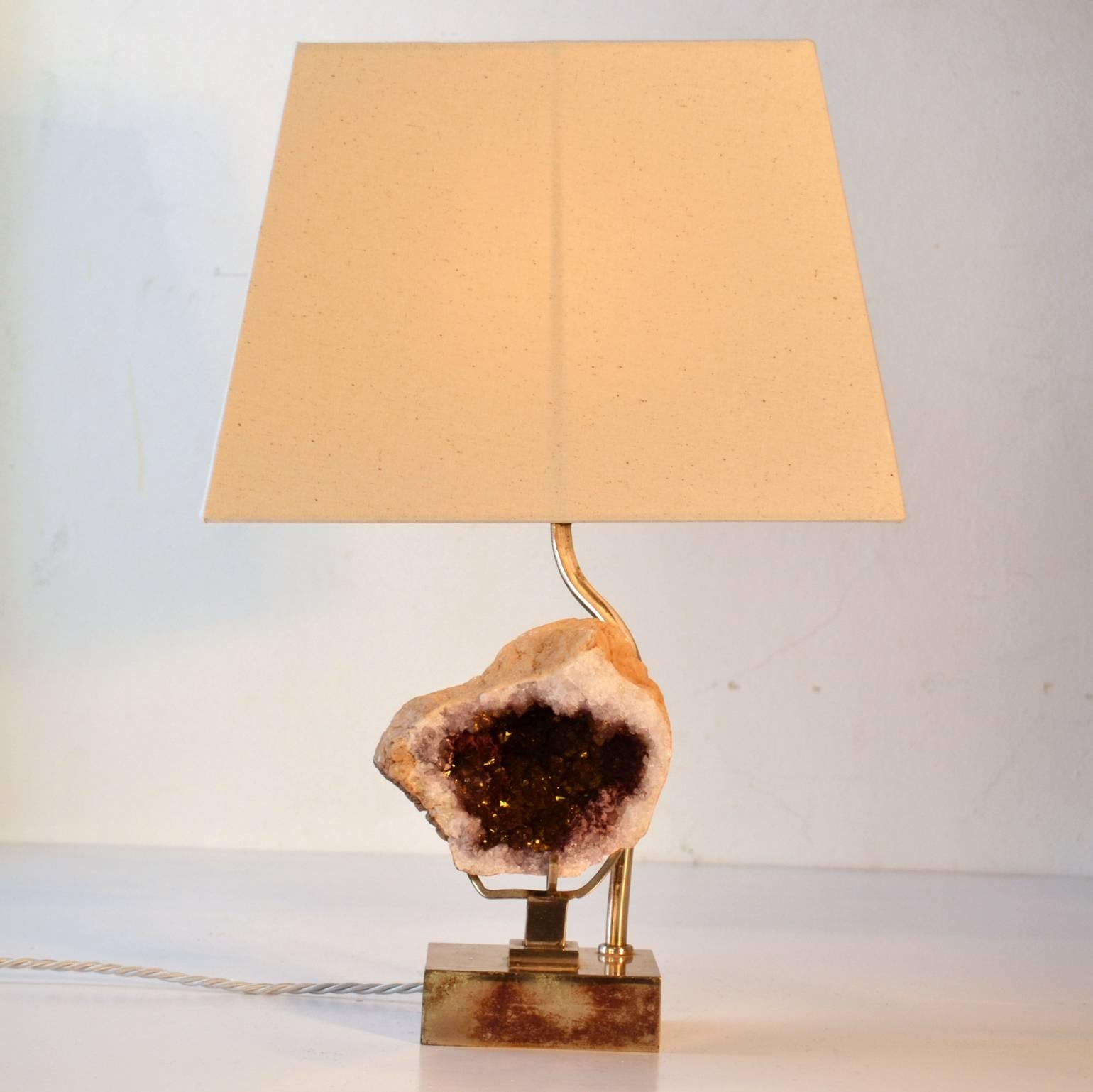 A pair of silver plated table lamps with original patina. At the centre rests amethyst stone on hand formed arms which sits on a stepped foot stand. The lights come with new cream stoned coloured rectangular shades. The light on to the mesmerizing