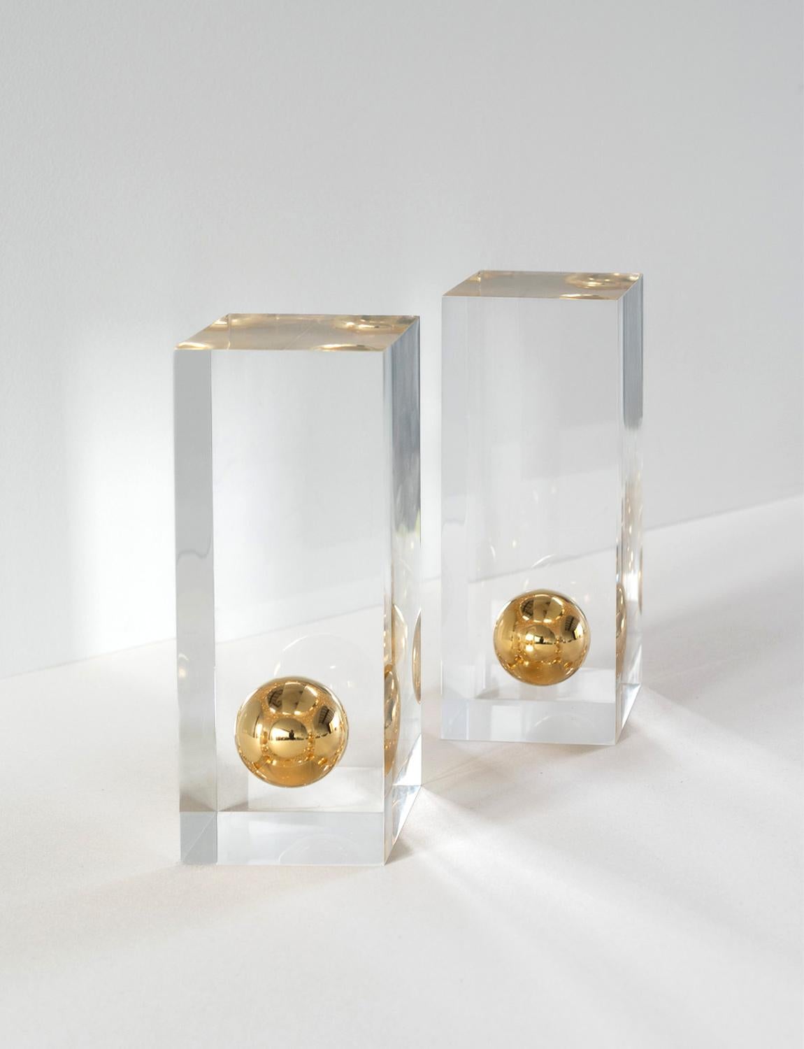 A wonderful pair of plexiglass ornaments designed by Willy Rizzo (1928 -2013) for Metal Art in the 1970s. A suspended gold orb sits within each ornament. They can be used as purely decorative pieces or as bookends. Willy Rizzo was a renowned Italian