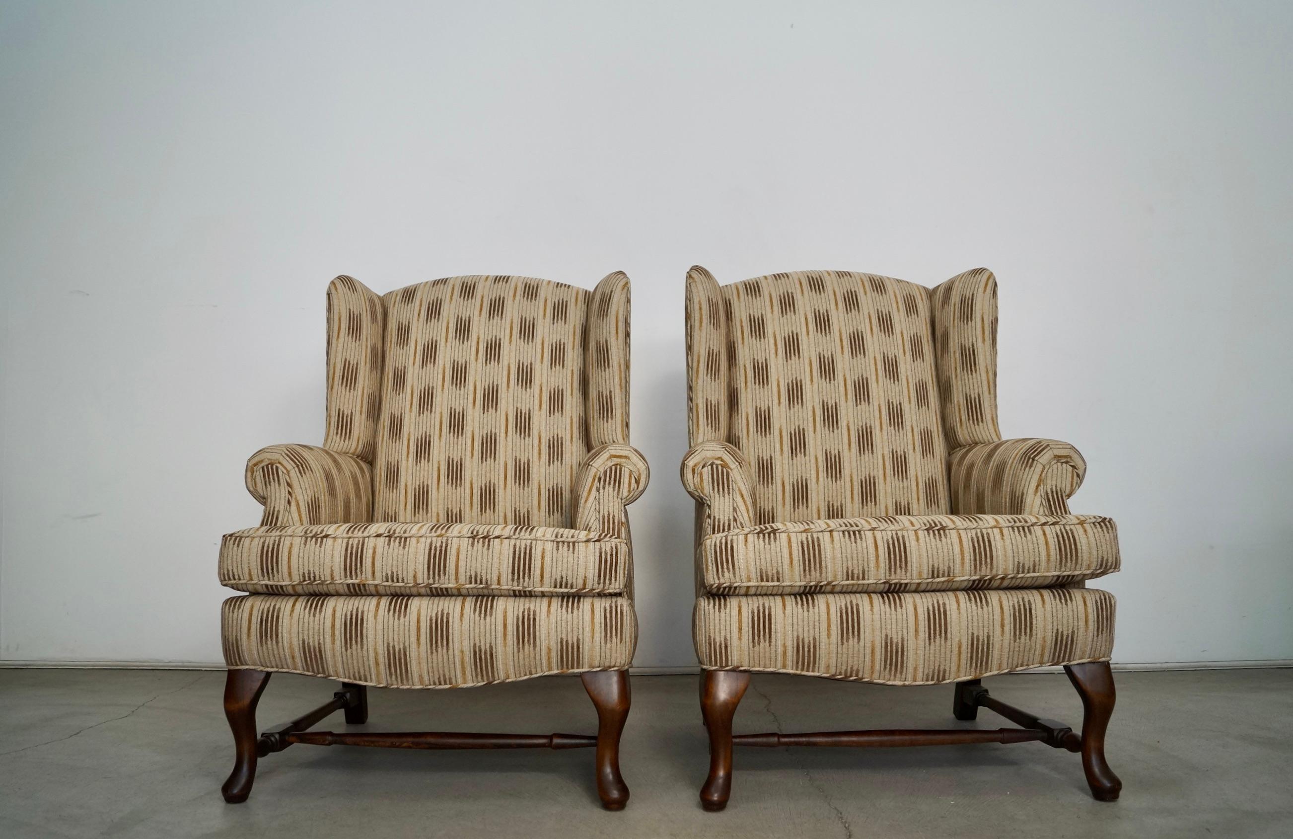 Vintage pair of wing chairs for sale. They are from the 1970's, and have been professionally restored. The wood bases and legs have been refinished in walnut, and have been reupholstered in new fabric and foam. The fabric is a beautiful linen with