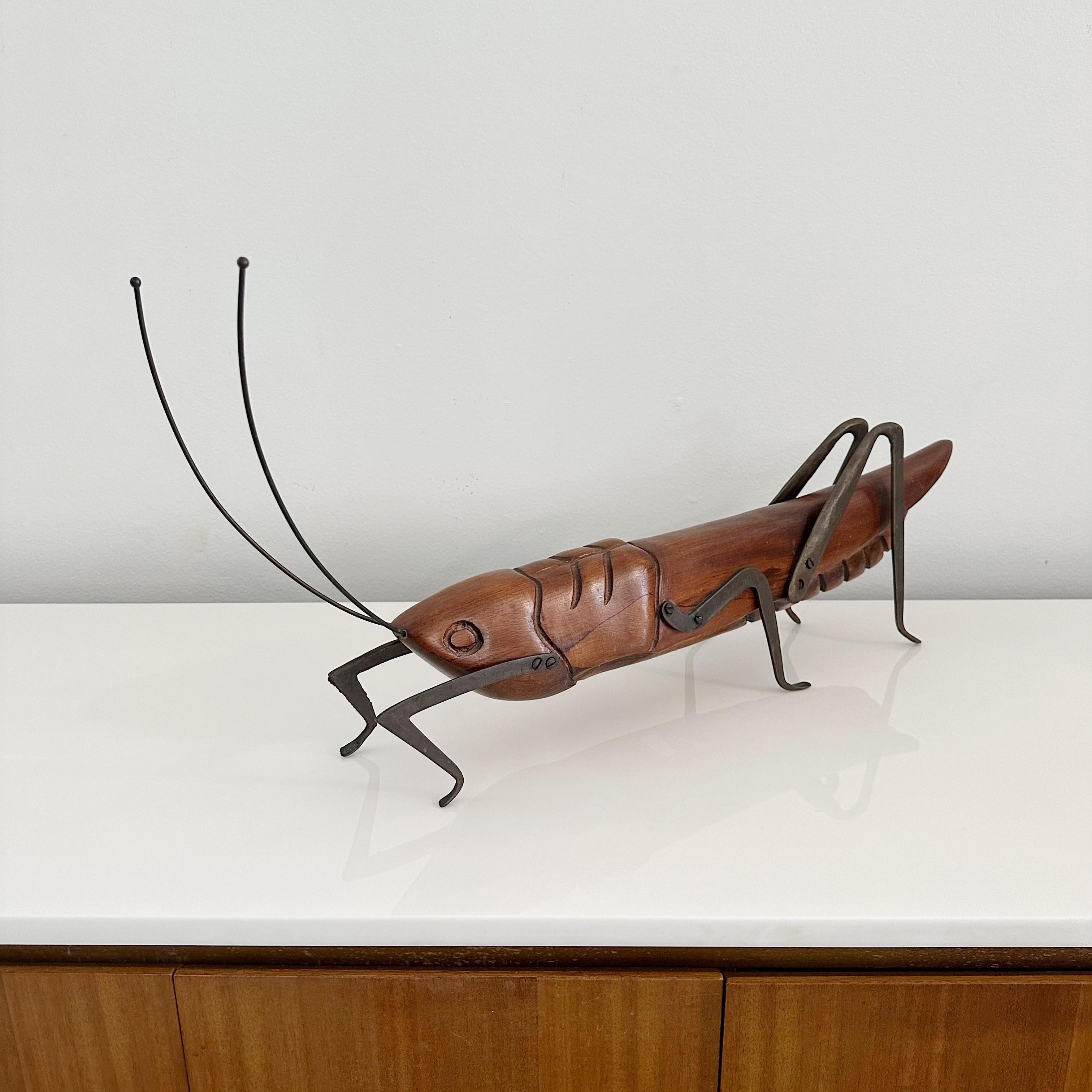 Hand Carved grasshopper sculpture by Sarreid Ltd of Spain, circa 1970s, Made in Italy.
Body of hand carved solid wood with accents in patinated brass