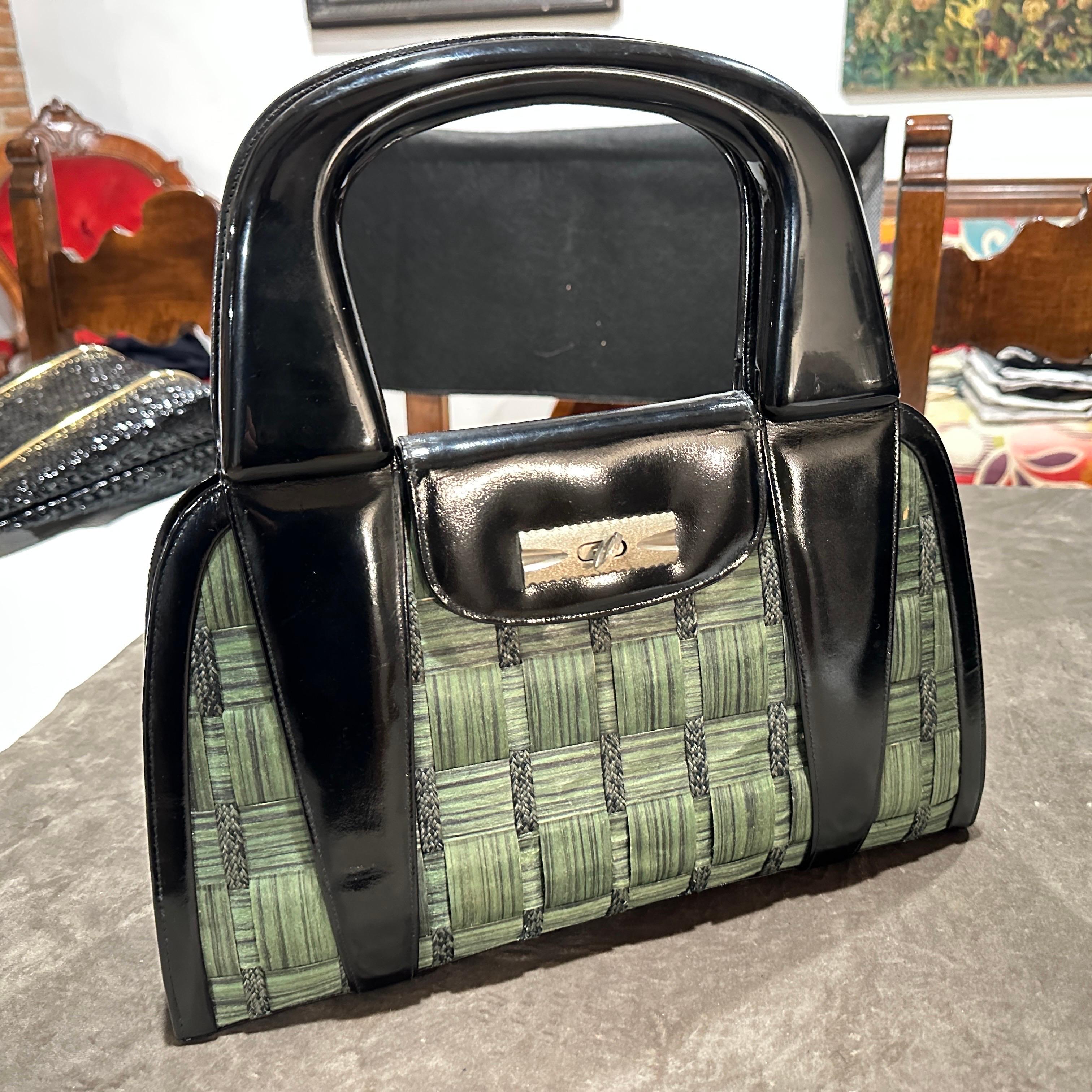 Schicke 1970er Jahre Vintage Italienische Henkeltasche aus gewebtem grünem Raffia und schwarzem Leder
Fangen Sie die Essenz der italienischen Eleganz der 1970er Jahre mit dieser stilvollen Vintage-Tasche mit oberem Griff ein. Dieses wunderschön