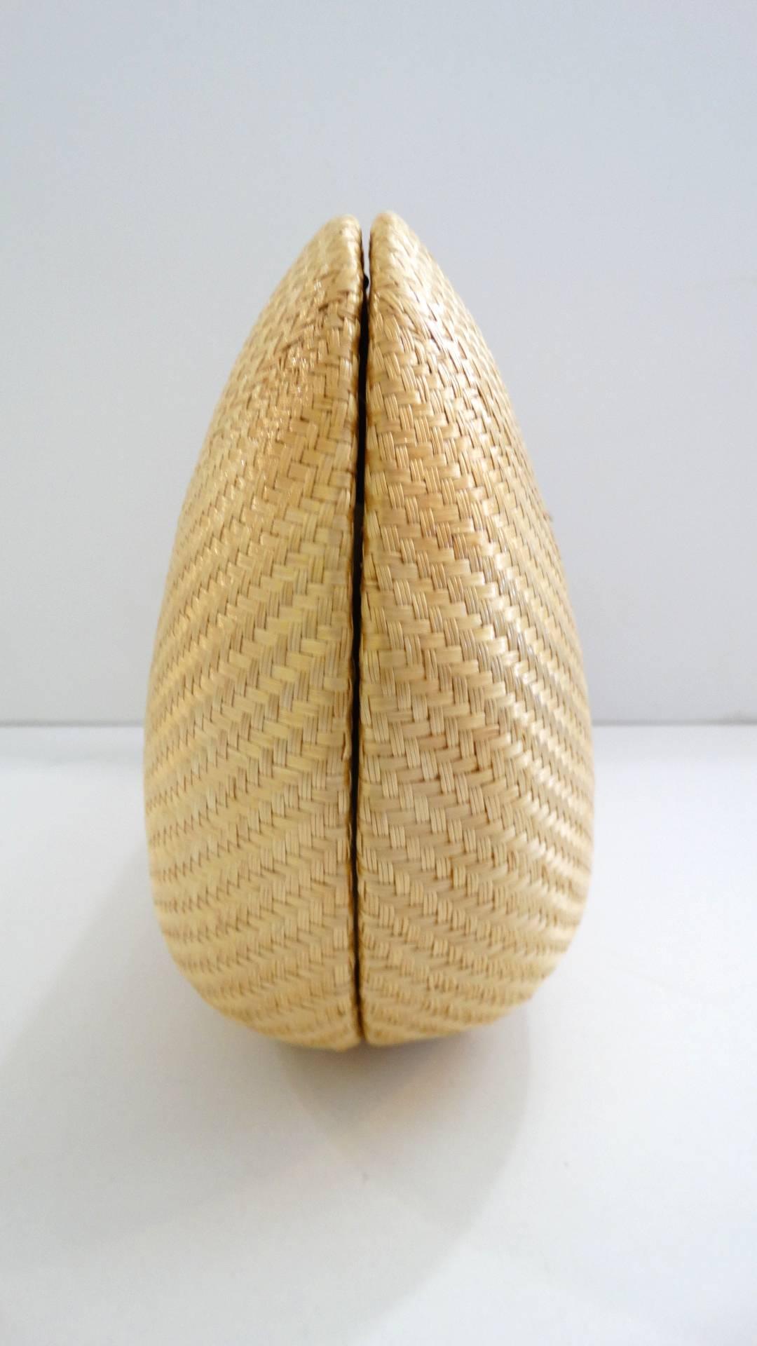 The most adorable little 1970s rattan bag! Made of a quality tan colored rattan material, tightly woven and contrasted with gold metal hardware! Bean shaped silhouette, comes with a gold chain strap that can be tucked in for wear as a clutch. Fully