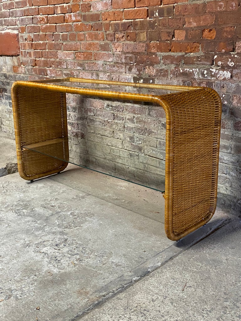 Fantastic 1970s wrapped wicker, glass and oak sofa/console table. The wicker is wrapped around a lightweight tubular metal substrate. Oak braces support the glass panels. Good overall condition with some minor wear consistent with age and use. Some