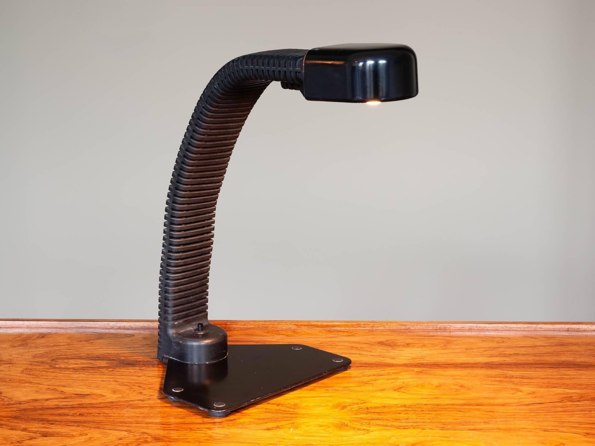 A flexible Cobra desk lamp designed by Kisho Kurokawa and produced by Yamagiwa. The lamp is made from black lacquered metal and rubber with a built in switch on the base. The light is flexible and adjustable to your own height and light